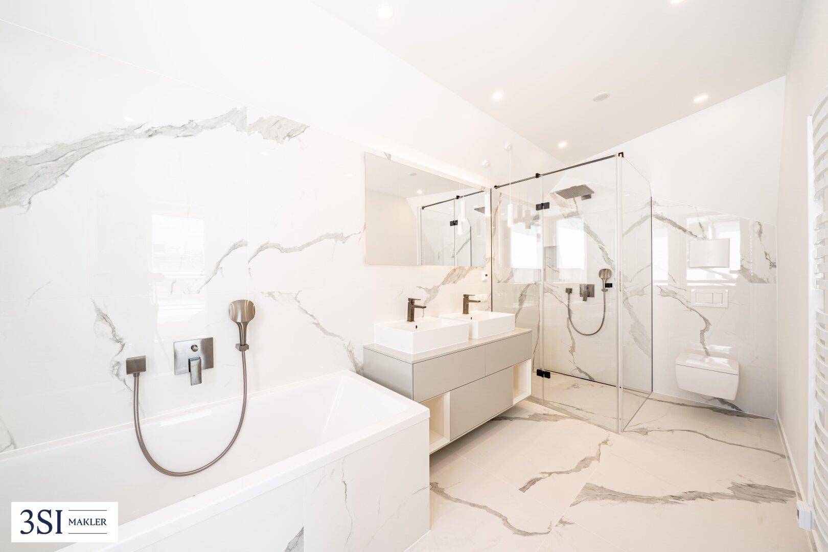 Elegantes Badezimmer mit Marmorfliesen, Doppelwaschbecken, Badewanne und großer Glasdusche.