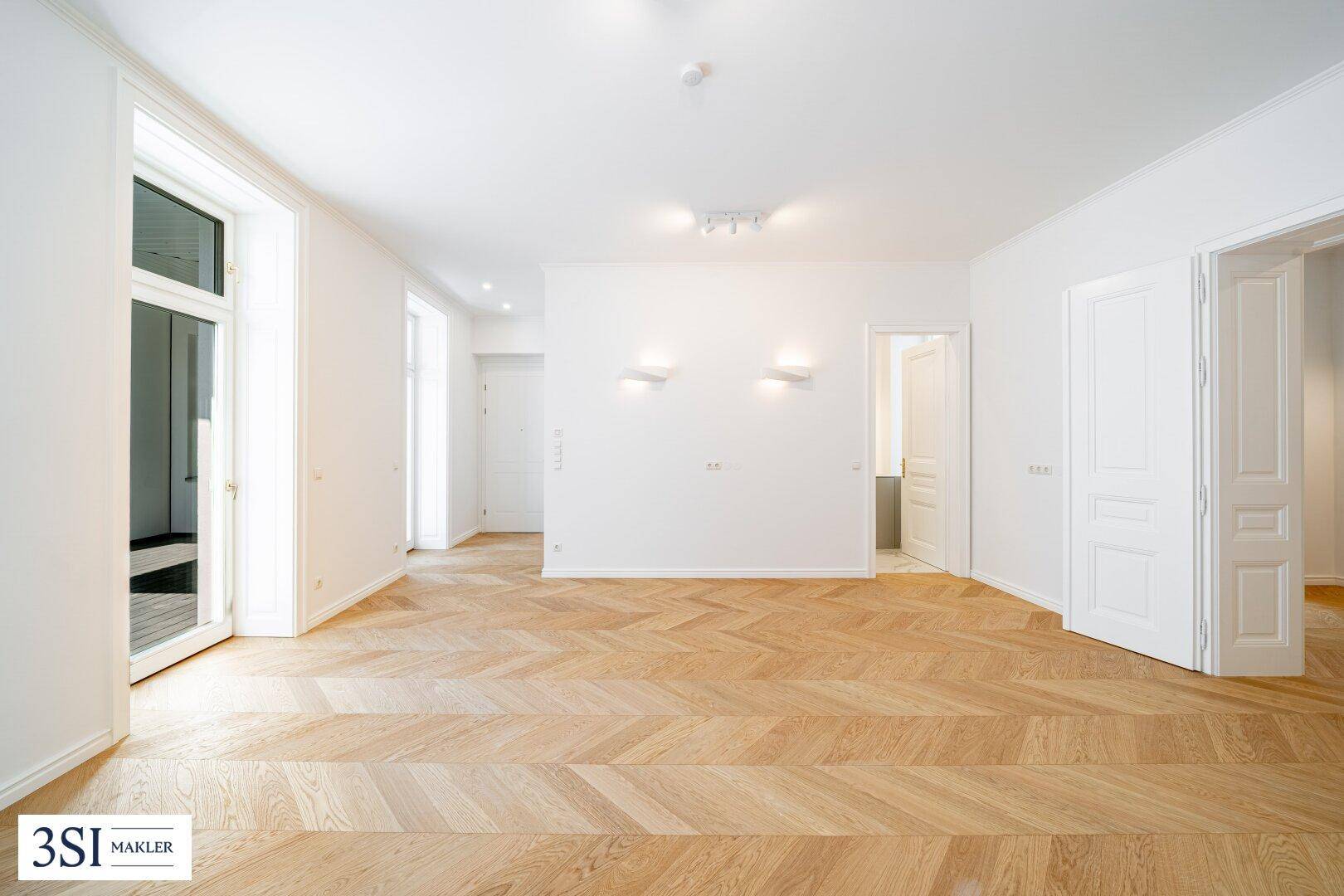 Heller Raum mit Fischgrätparkett, hohen Decken und großen Fenstern, bereit zum Einrichten.