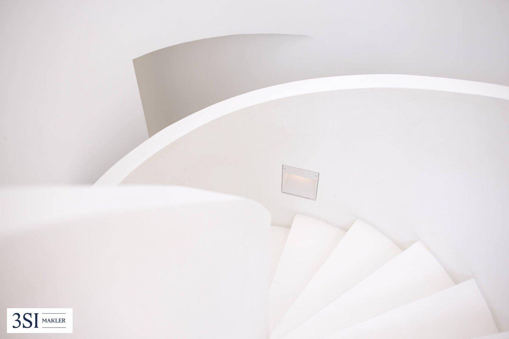 Detailaufnahme der eleganten, weißen Wendeltreppe mit integrierter Beleuchtung.
