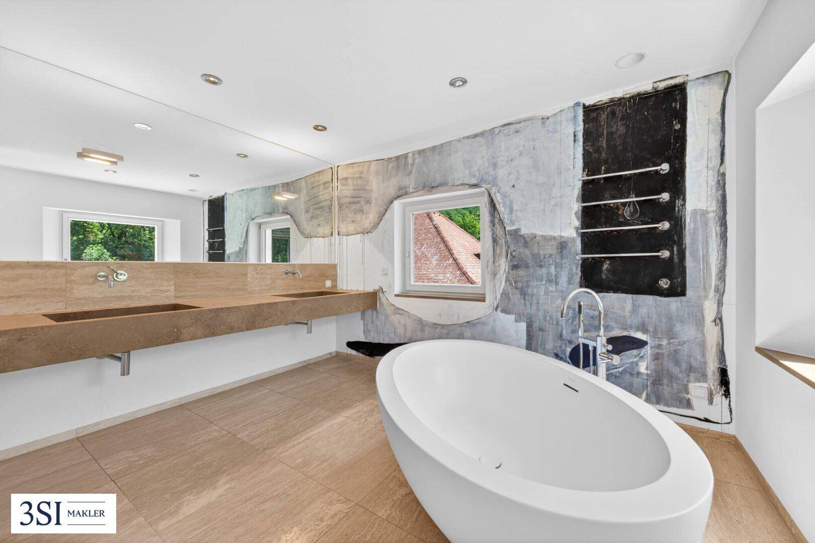 Modernes Badezimmer mit freistehender Badewanne, Doppelwaschbecken und künstlerischer Wandgestaltung.