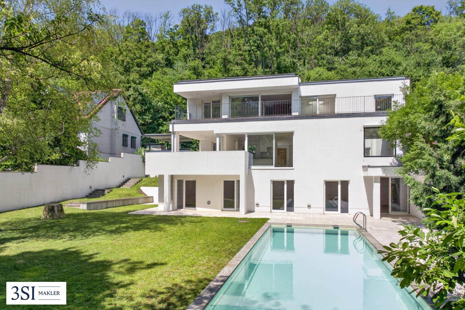 Elegante moderne Villa mit weitläufigem Garten, Pool und Blick auf bewaldete Hügel.