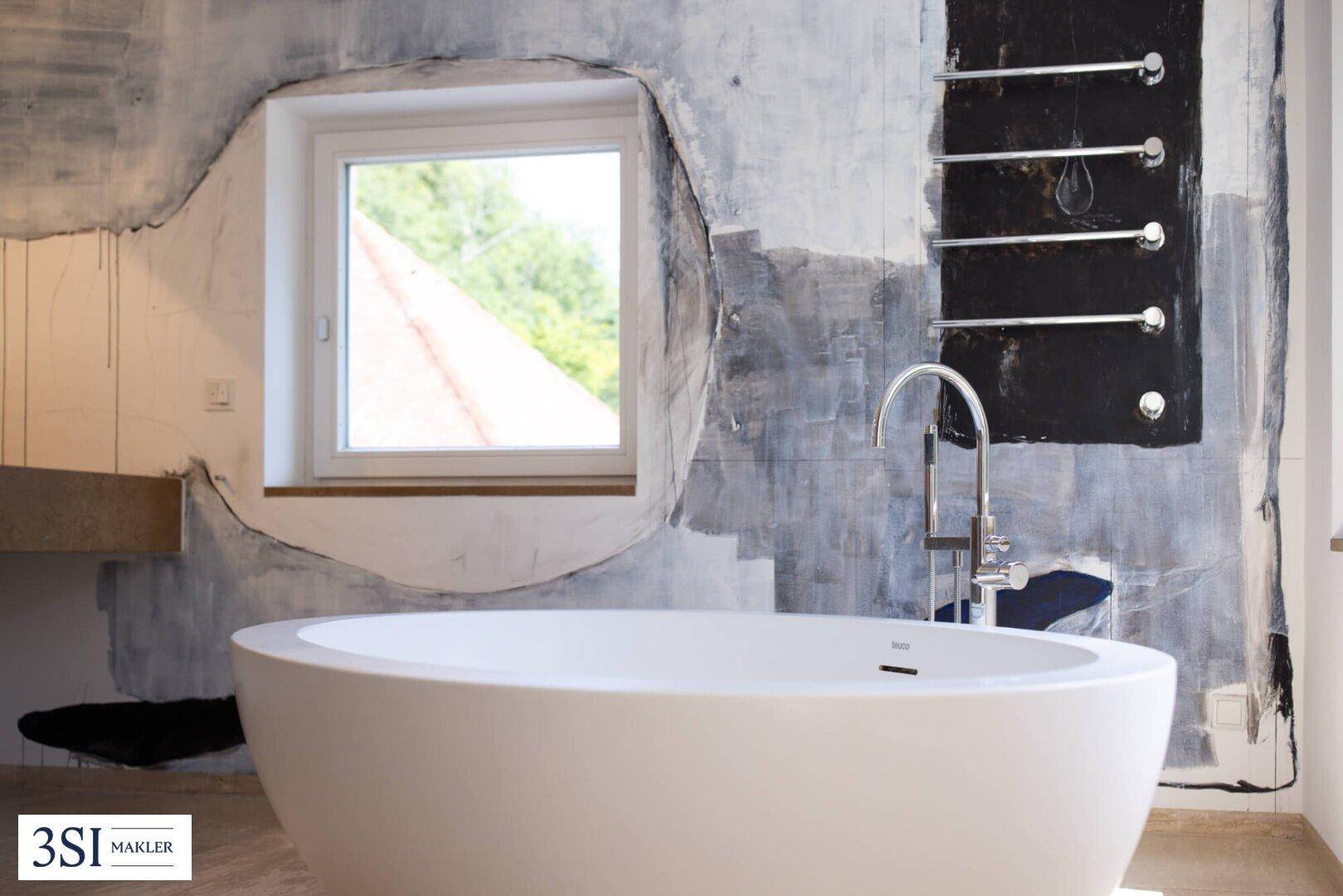 Detailansicht der freistehenden Badewanne in einem modernen Badezimmer mit Fenster.