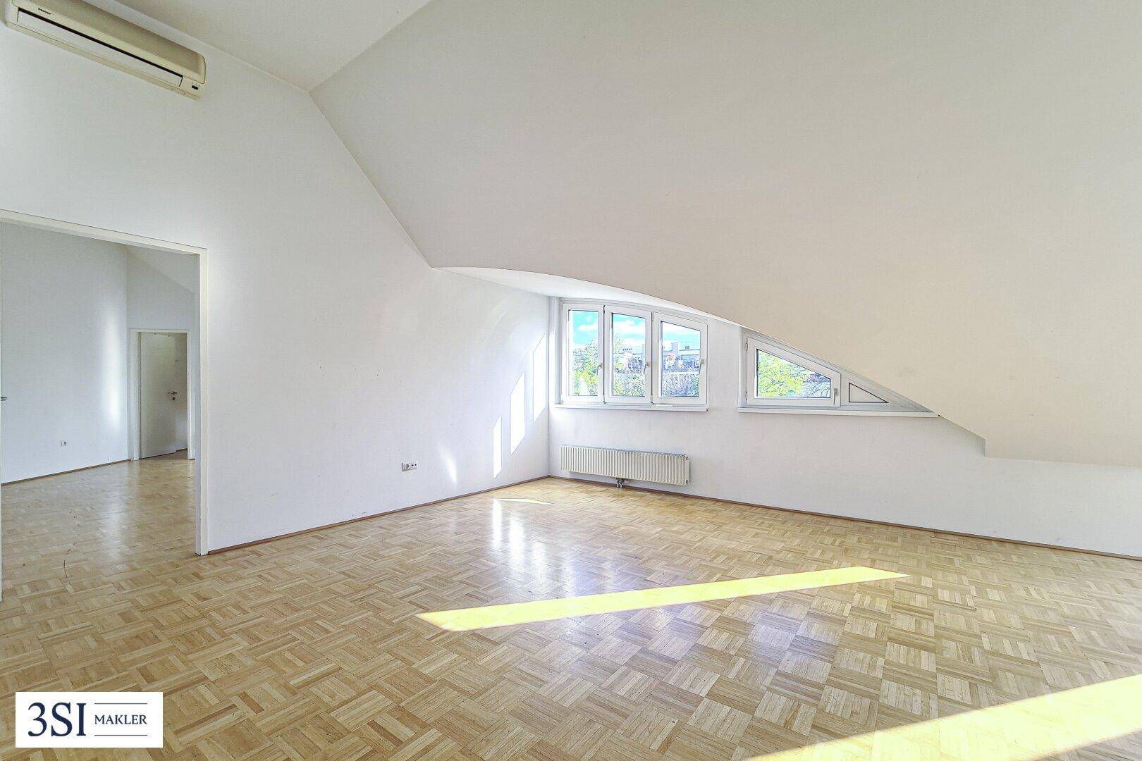 Geräumiges Zimmer mit Parkettboden, Dachschrägen und Klimaanlage für angenehmes Raumklima.