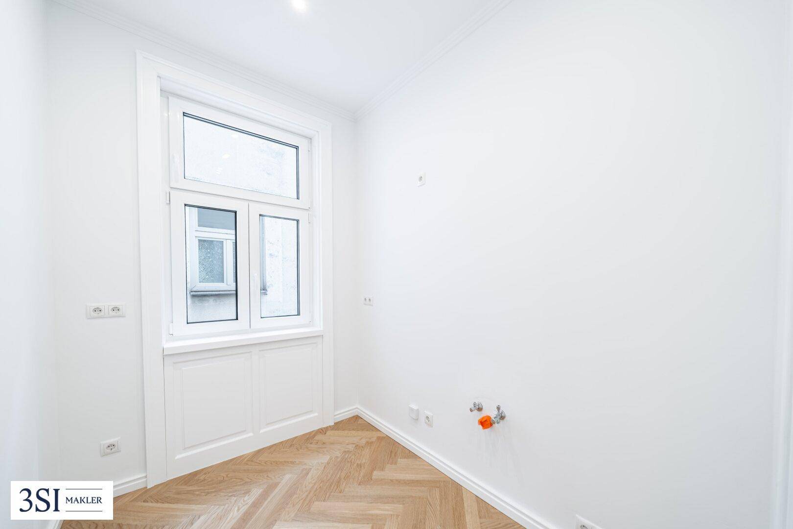 Kleines, helles Zimmer mit Fischgrätparkett und einem großen Fenster, ideal als Kinder- oder Arbeitszimmer.