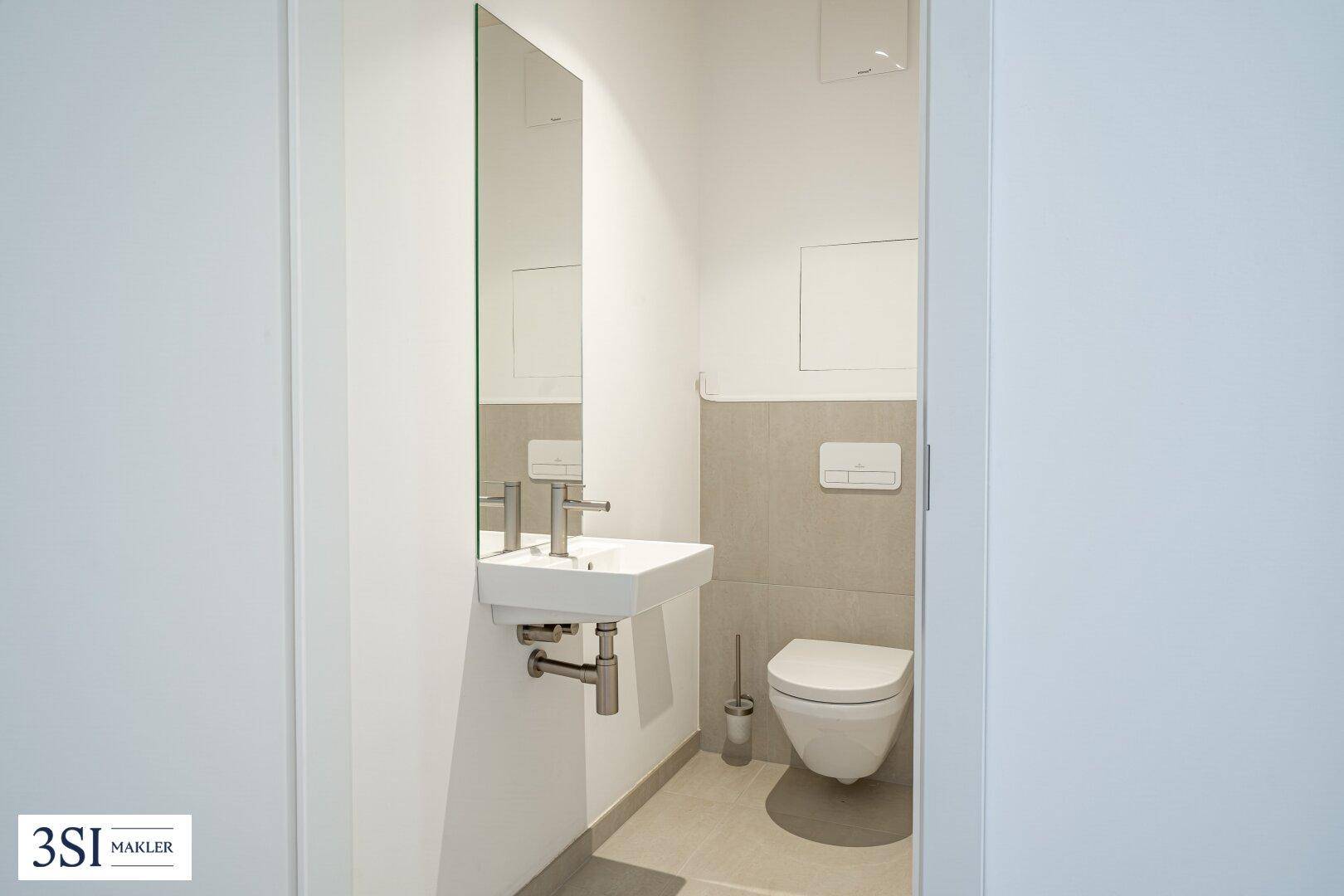 Kleines Gäste-WC mit wandhängendem WC und modernem Waschbecken.