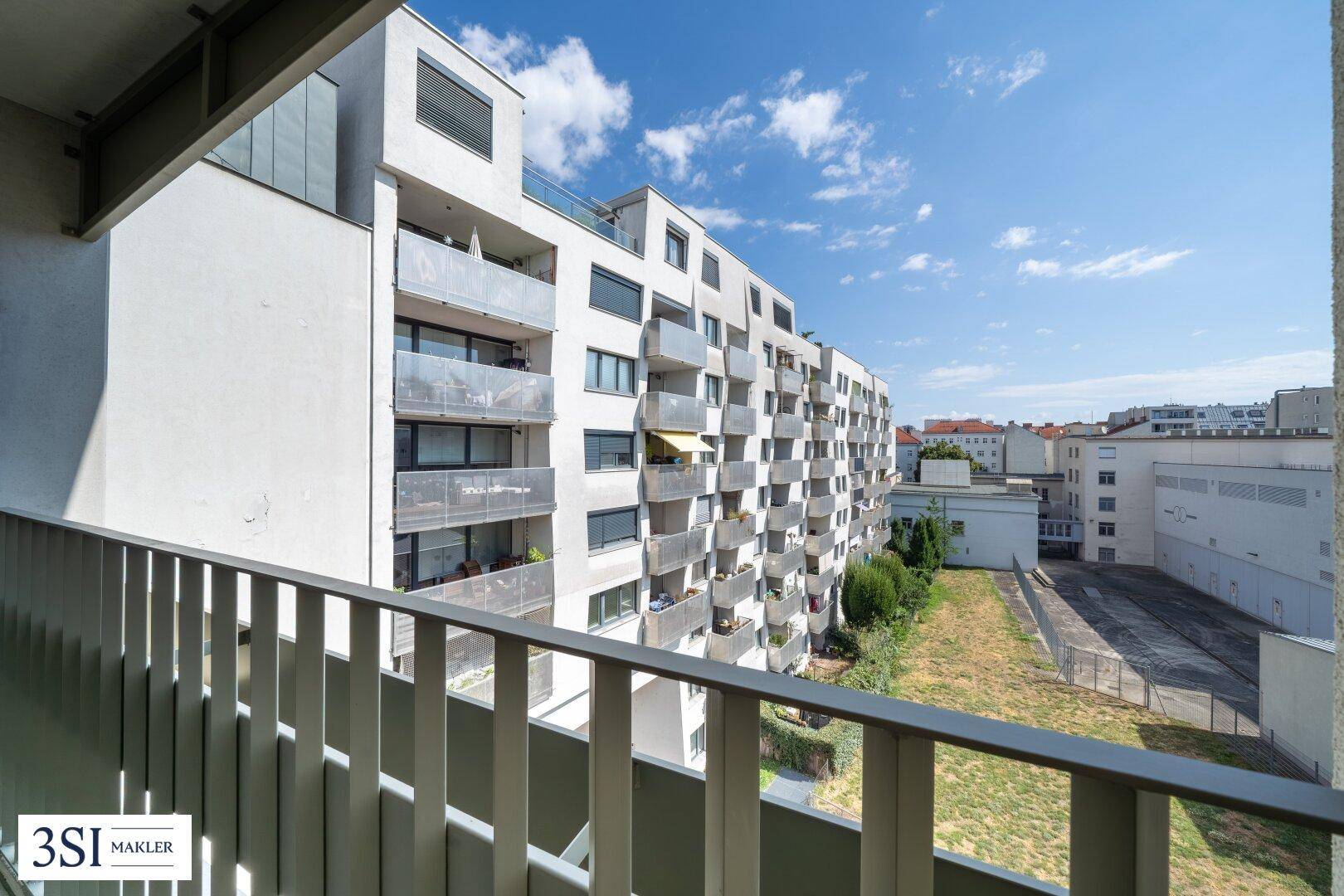 Geräumiger Balkon mit moderner Brüstung und Ausblick auf die Stadt.