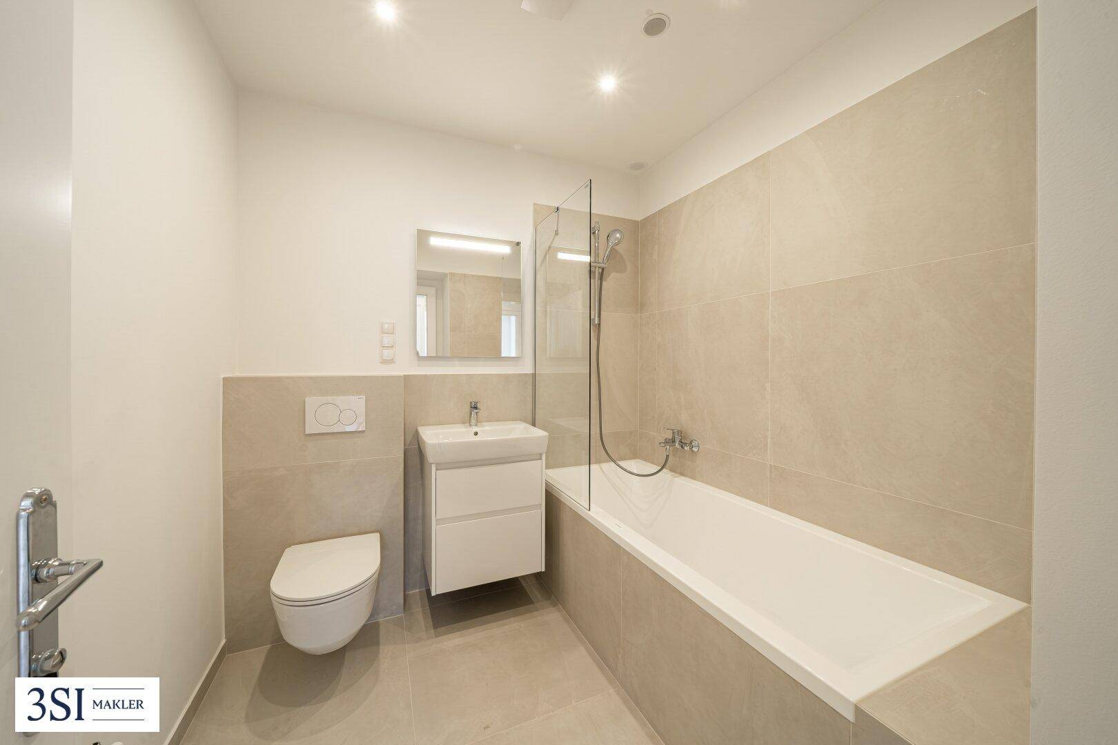 Modernes Badezimmer mit Badewanne, Dusche, WC und Waschbecken in hellen Beigetönen.