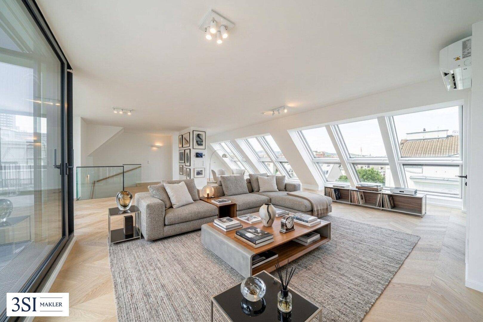 Modern eingerichtetes Wohnzimmer mit bequemer Couch, Couchtisch und Blick durch große Dachfenster.