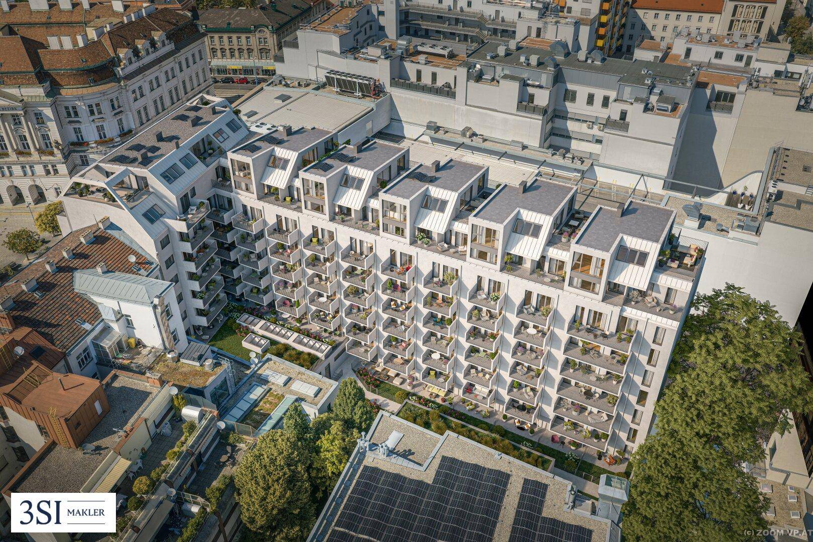 Weitläufige Luftaufnahme eines modernen Wohnkomplexes mit begrünten Innenhöfen in urbaner Umgebung.