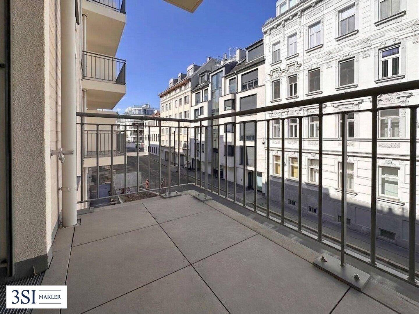 Breiter Balkon mit Metallgeländer und Panoramablick auf die städtische Umgebung und Architektur.