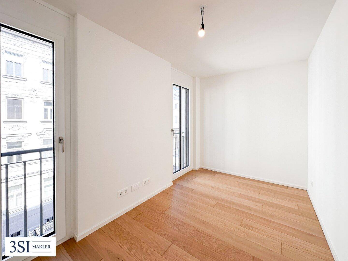 Helles Schlafzimmer mit Holzboden und zwei französischen Balkonen mit Stadtblick.