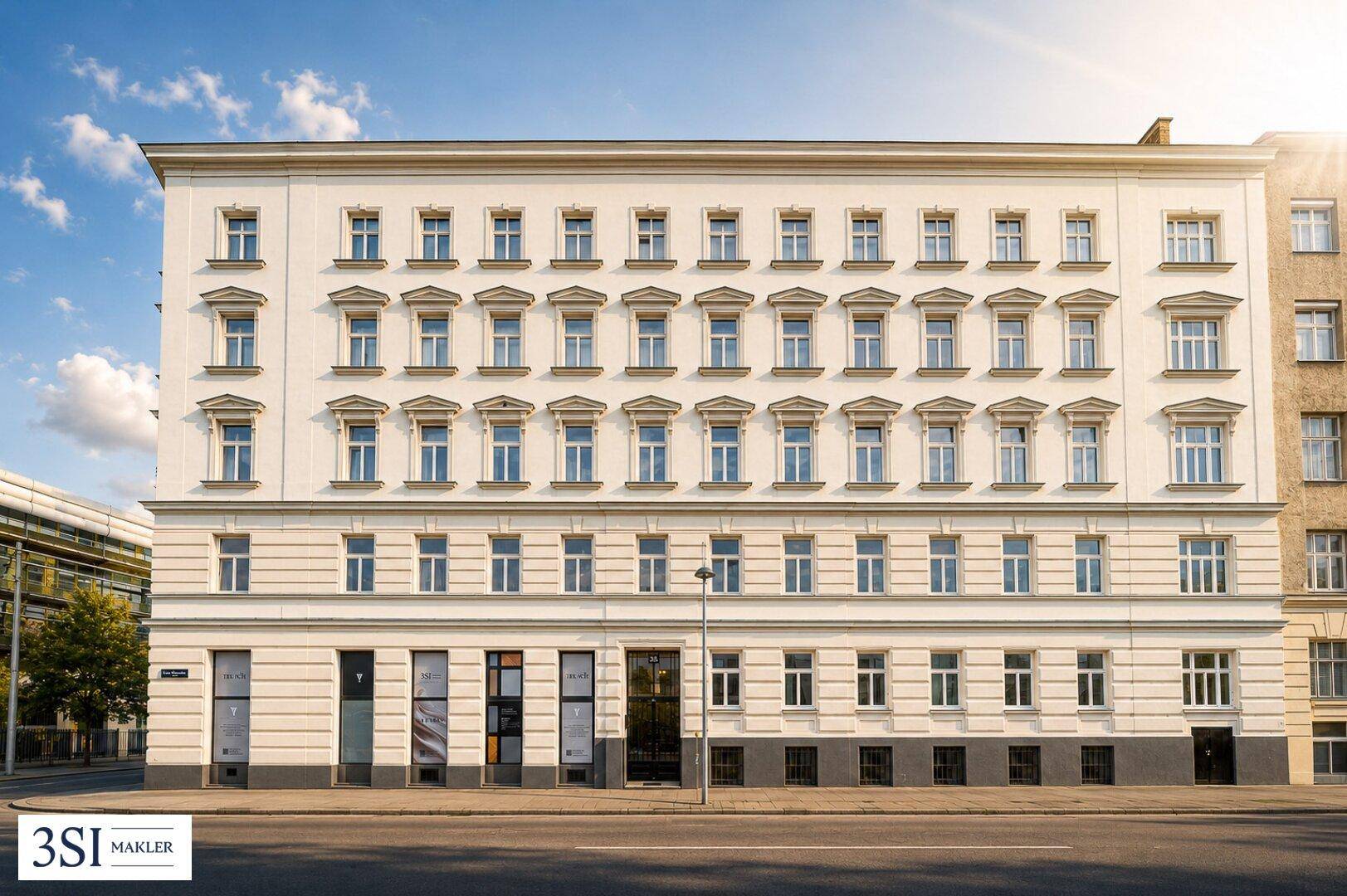 Klassische Fassade eines Altbaus mit vielen Fenstern und Geschäften im Erdgeschoss.