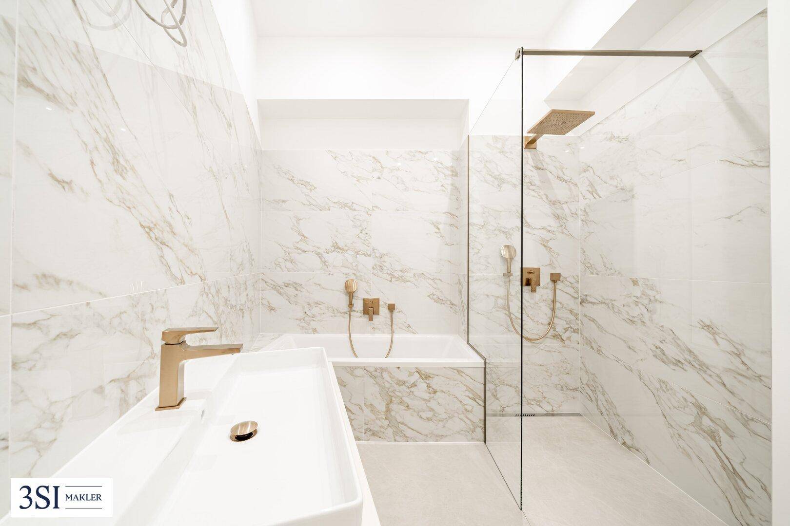 Luxuriöses Badezimmer mit Badewanne, ebenerdiger Dusche und Waschtisch in Marmoroptik.