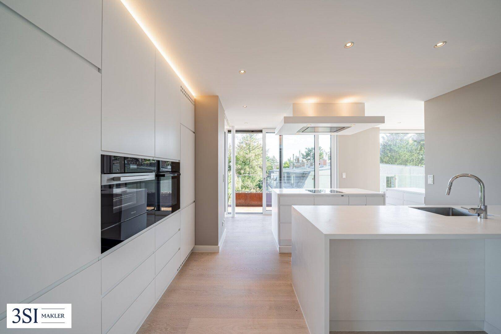 Elegante Einbauküche mit minimalistischem Design, hochwertigen Geräten und viel Stauraum.