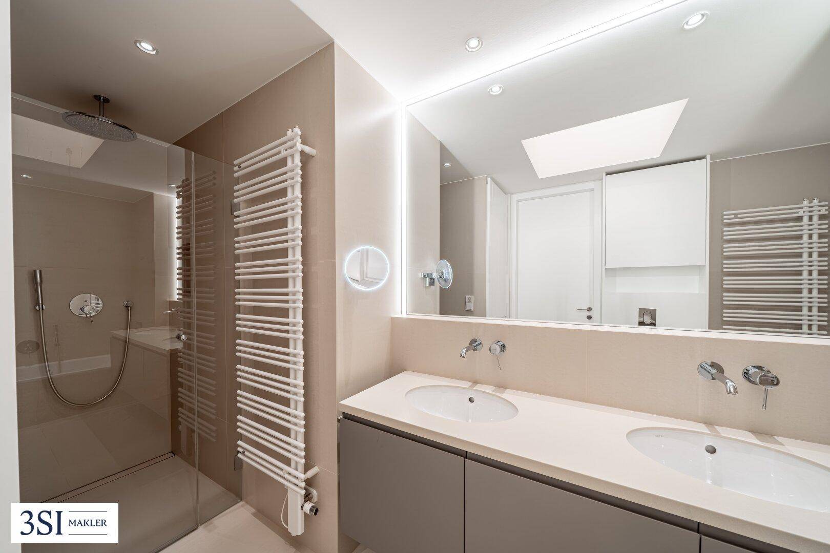 Modernes Badezimmer mit Doppelwaschbecken, großer Spiegelfläche und begehbarer Dusche.