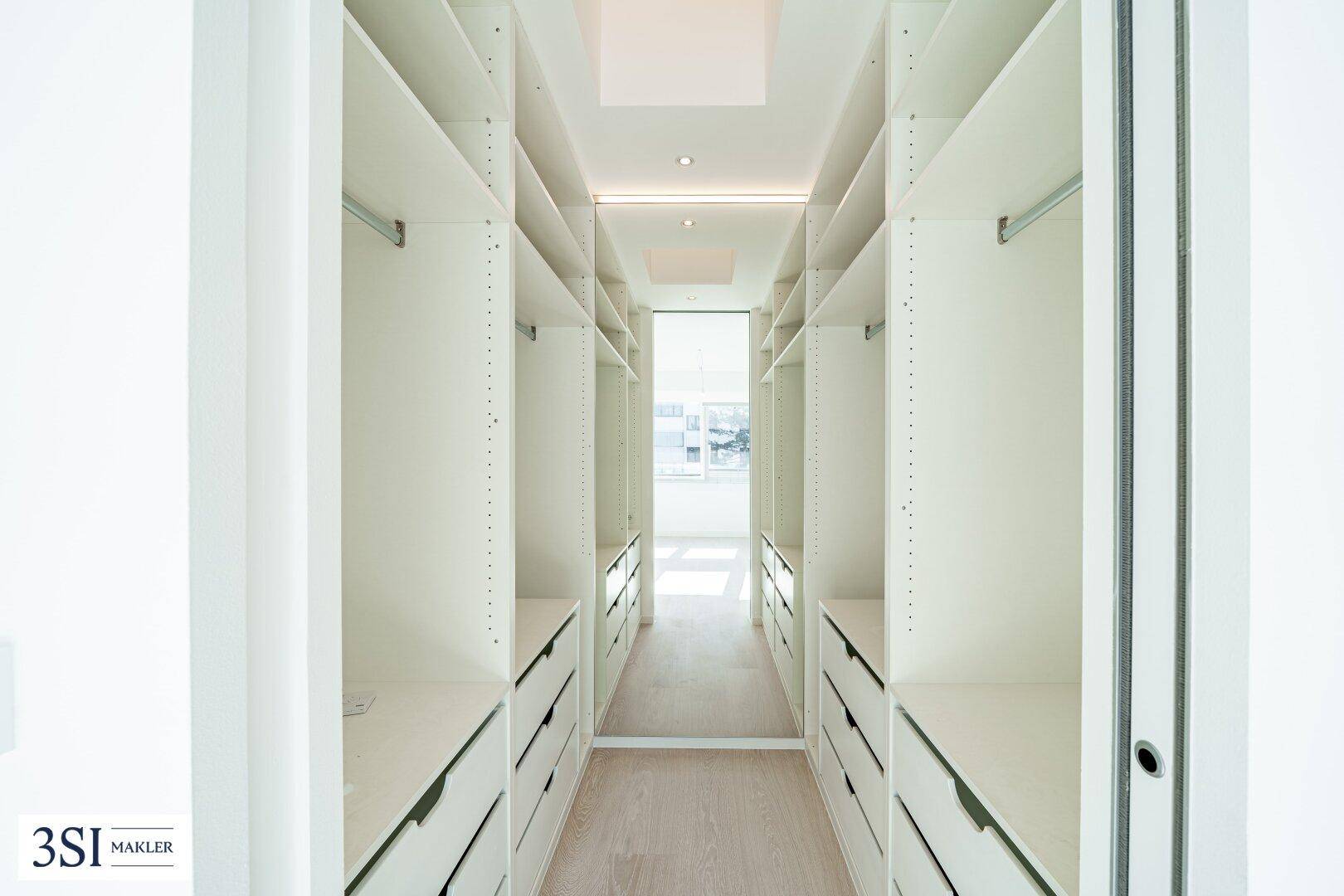 Geräumiger begehbarer Kleiderschrank mit vielen Ablagemöglichkeiten und Schubladen.