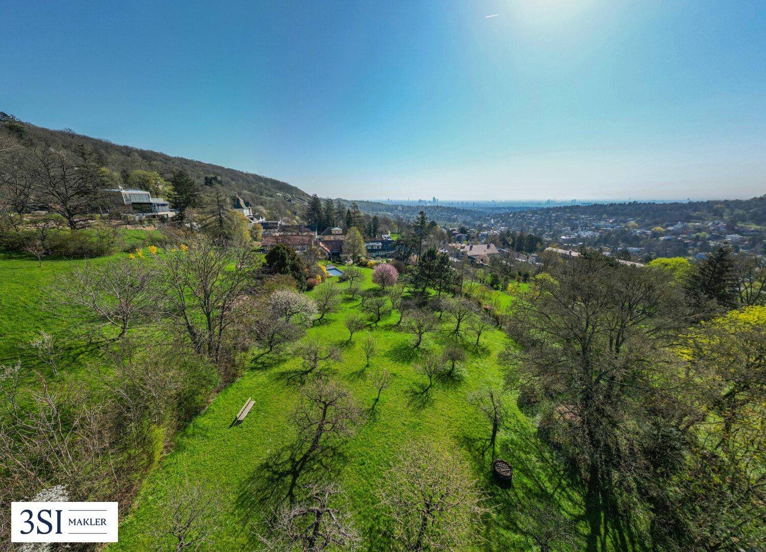 Weitläufiges Anwesen mit Obstbäumen und Panoramablick über die umliegende Landschaft und Stadt.