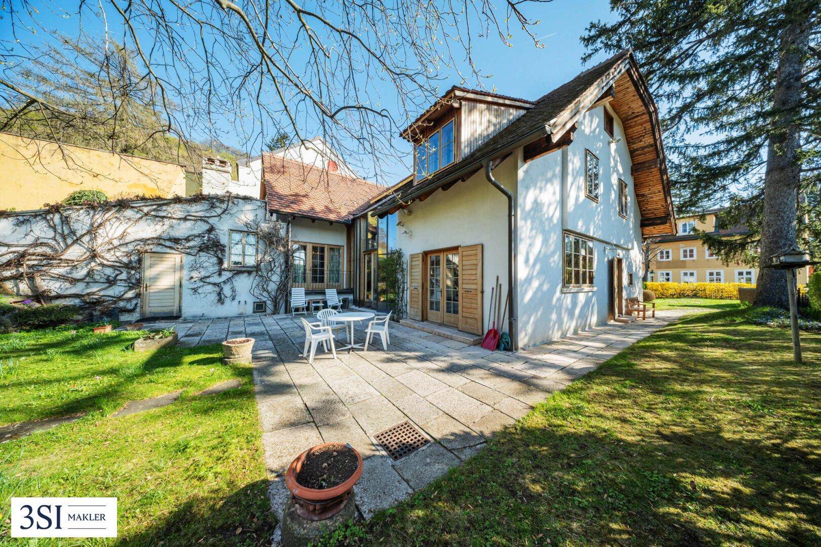 Geräumige Steinterrasse mit Gartenmöbeln und direktem Zugang zum Haus und Garten.