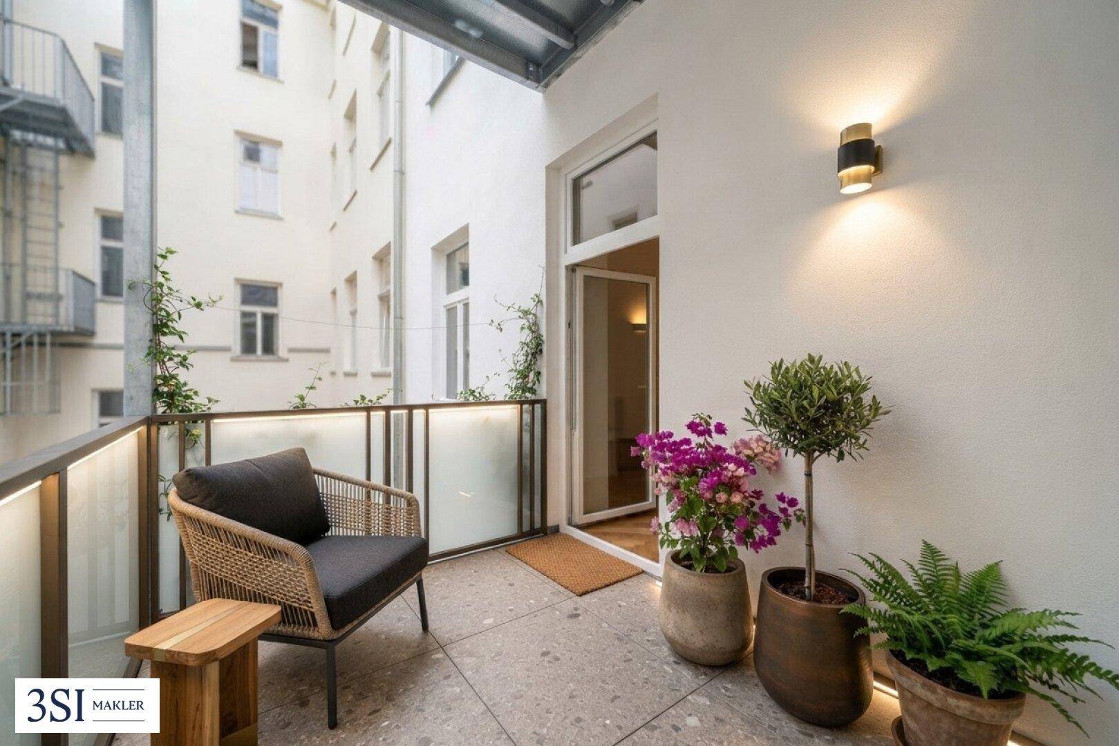 Gemütlicher Balkon mit Fliesenboden und Pflanzen, ideal für entspannte Stunden im Freien.
