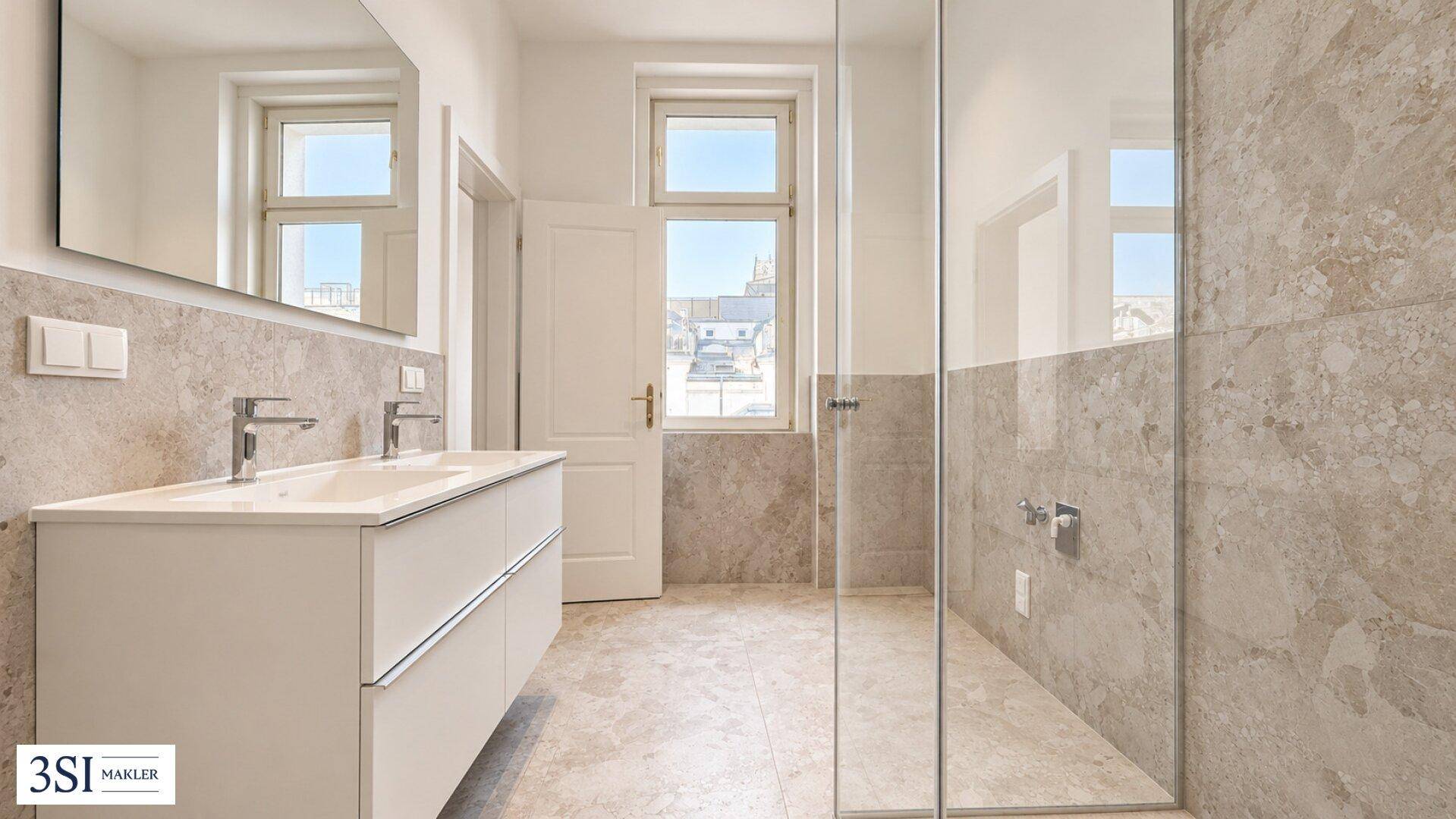 Modernes Badezimmer mit Doppelwaschbecken, begehbarer Dusche und hellen Fliesen.