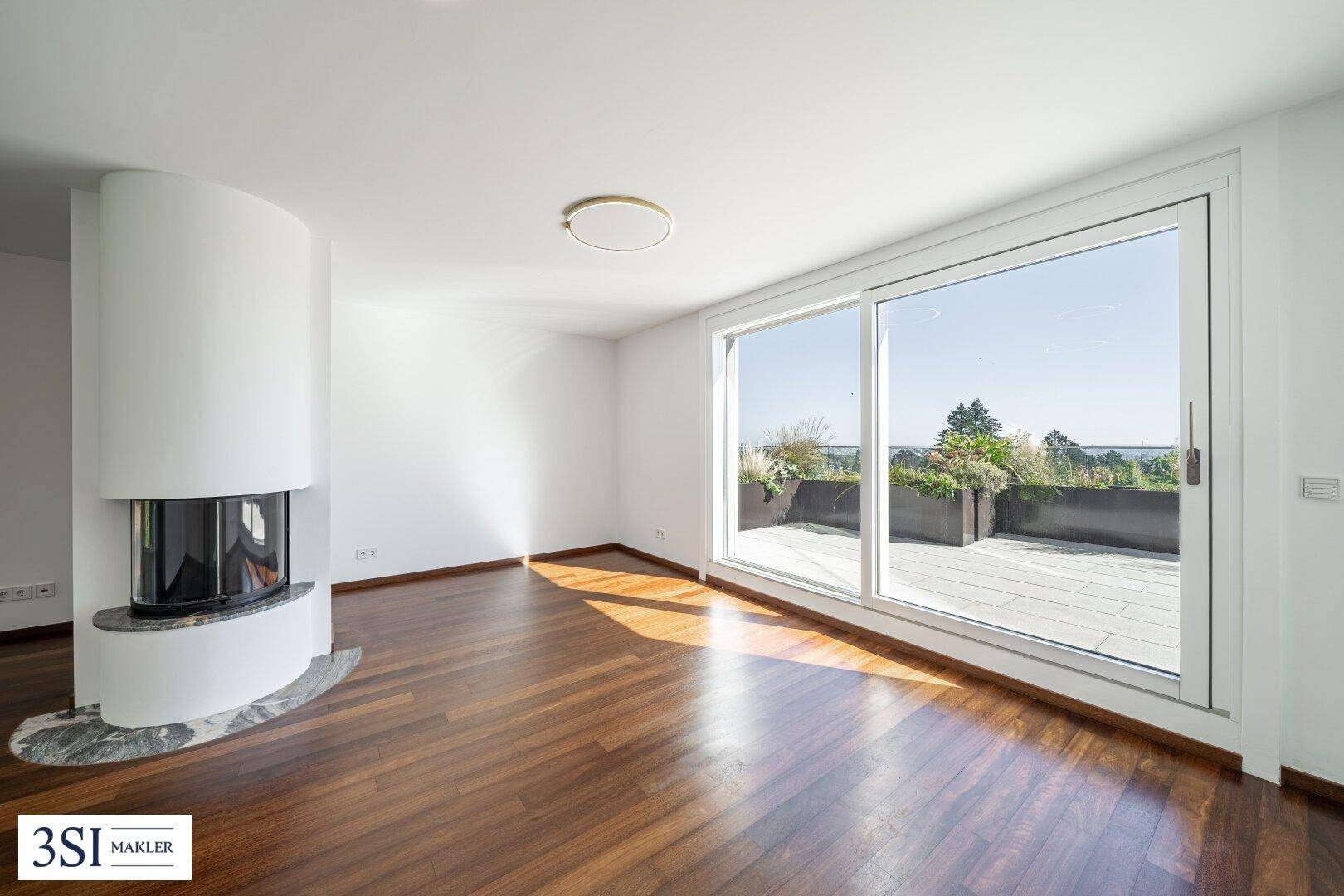 Geräumiges Wohnzimmer mit modernem Kamin, dunklem Holzparkett und Zugang zu einer sonnigen Terrasse.