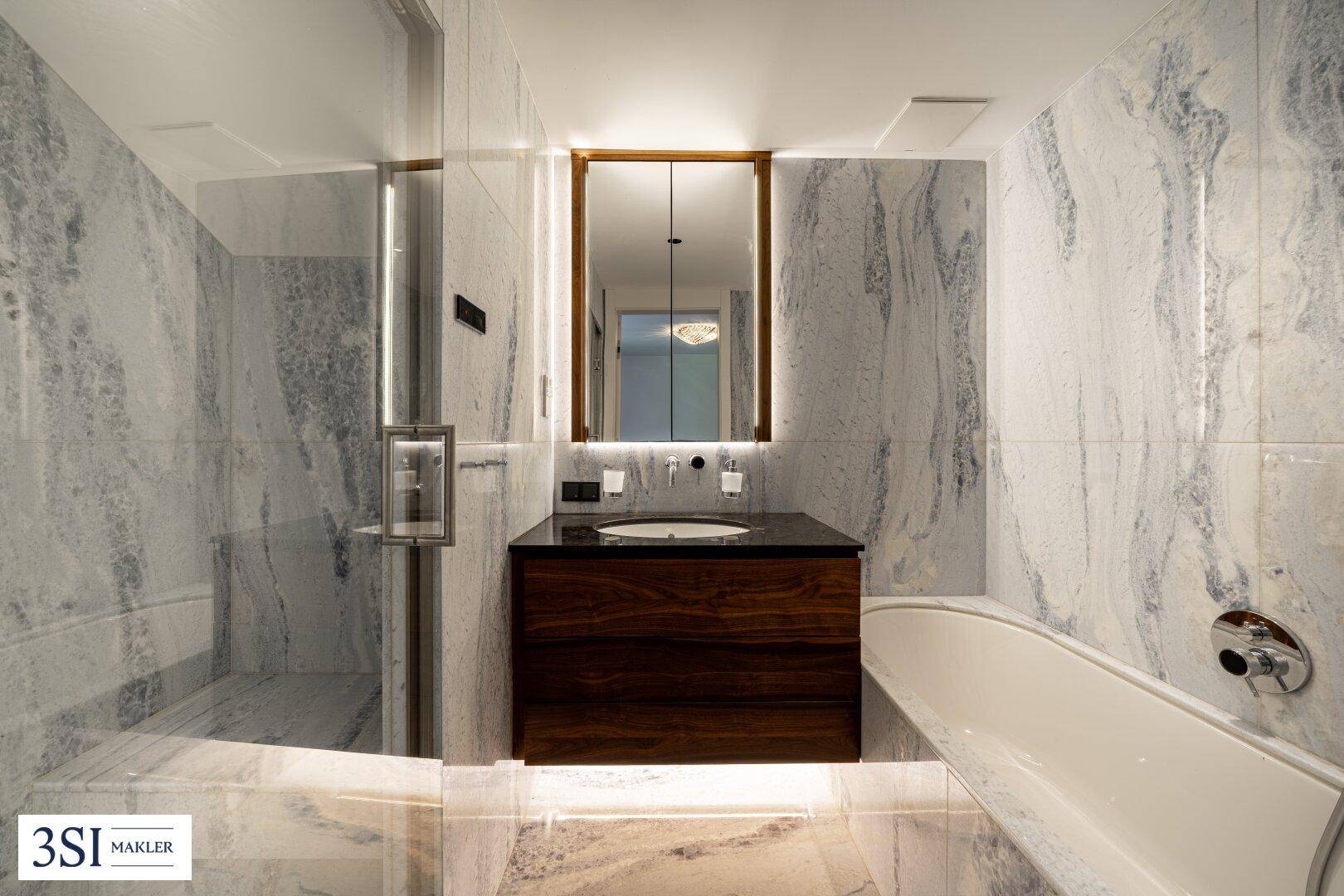 Luxuriöses Badezimmer mit Marmorfliesen, begehbarer Dusche und moderner Badewanne.