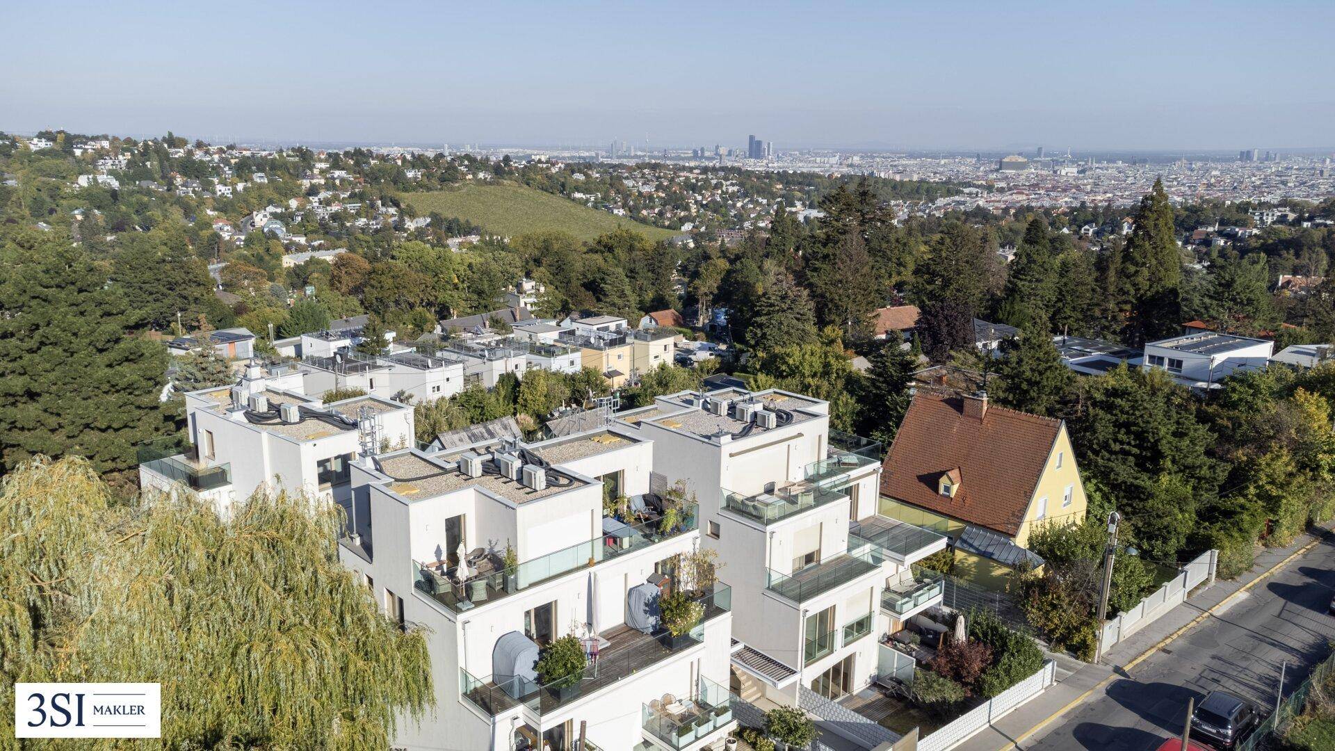 Wohngebäude mit Terrassen und weitem Blick über die Stadt und die umliegende Hügellandschaft.