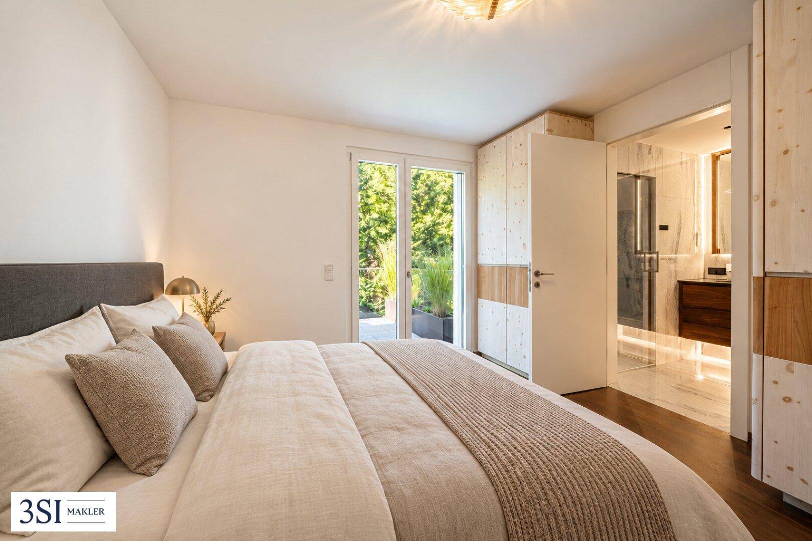 Gemütliches Schlafzimmer mit Doppelbett, Holzschränken und direktem Zugang zu einem modernen Badezimmer.