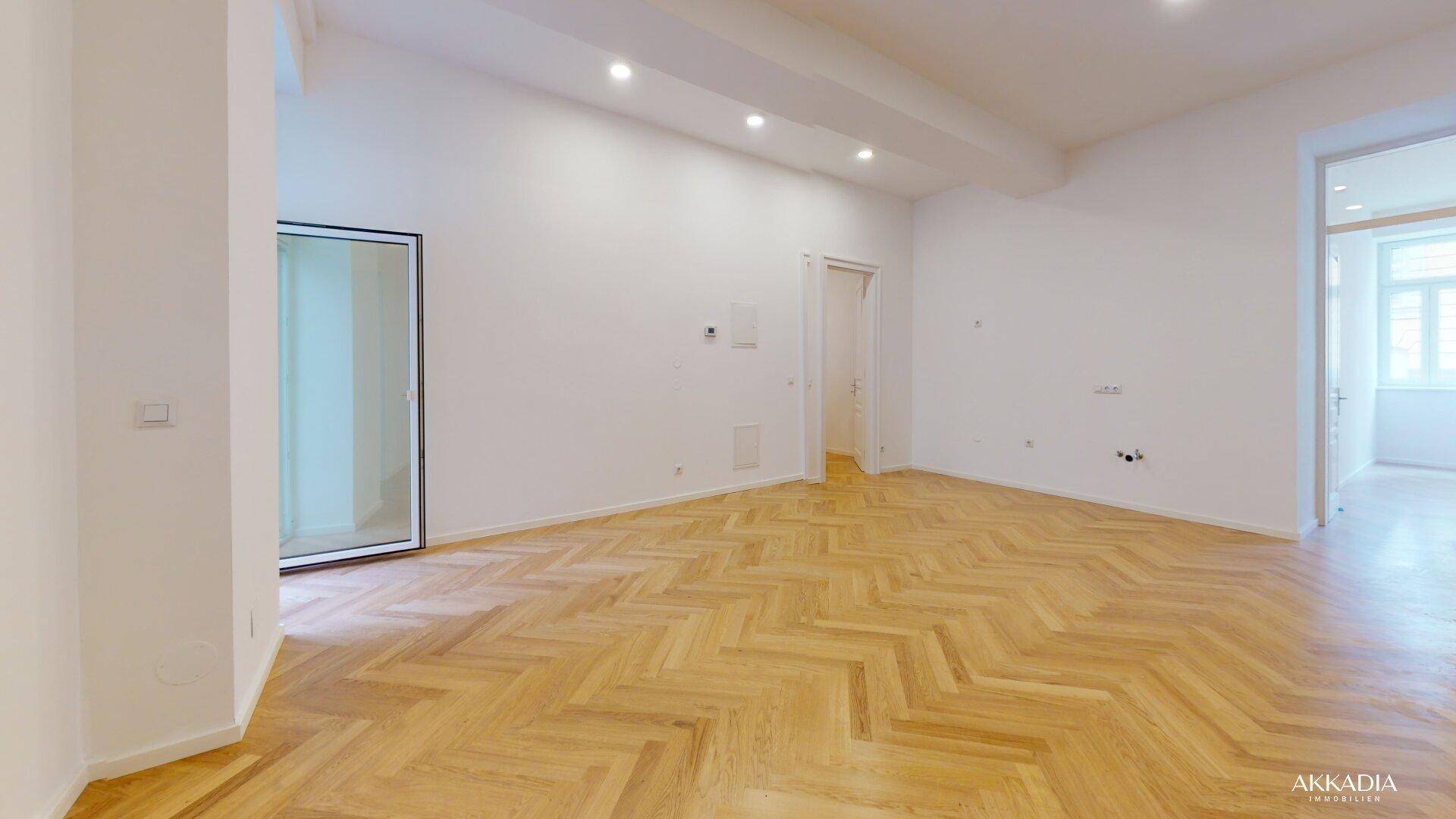Helles, leeres Zimmer mit Fischgrätparkett und Einbaustrahlern, bereit zur individuellen Gestaltung.