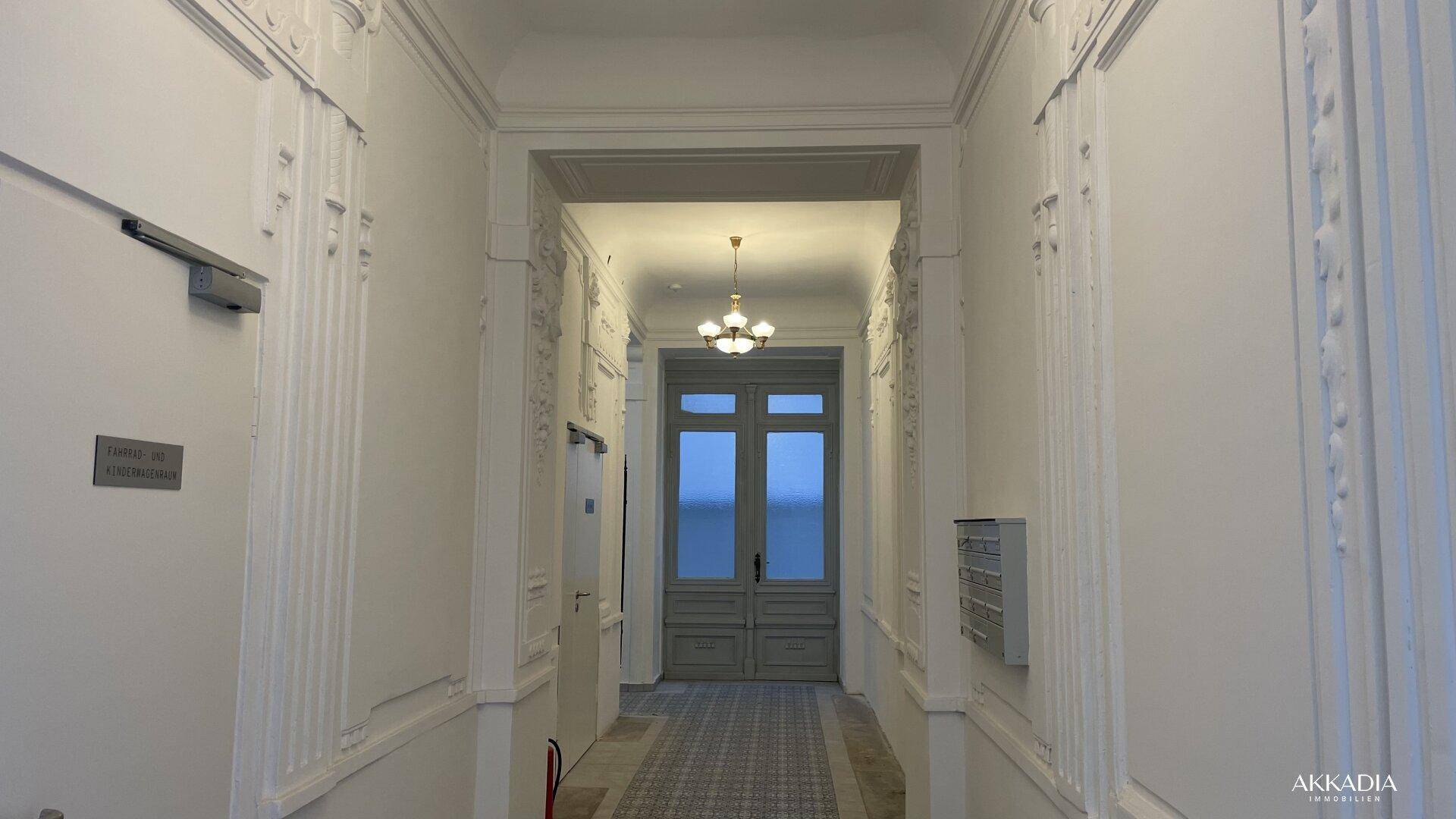 Eleganter Eingangsbereich mit Stuckverzierungen, hohen Decken und klassischem Design.