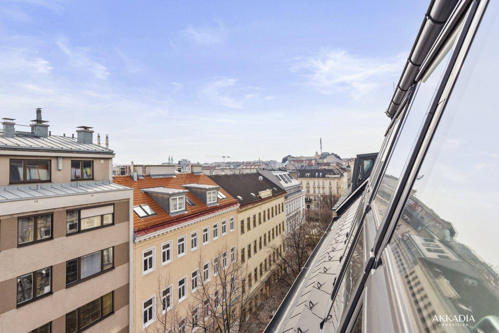 Weitblick über die Dächer der Stadt mit historischen Gebäuden und blauem Himmel.