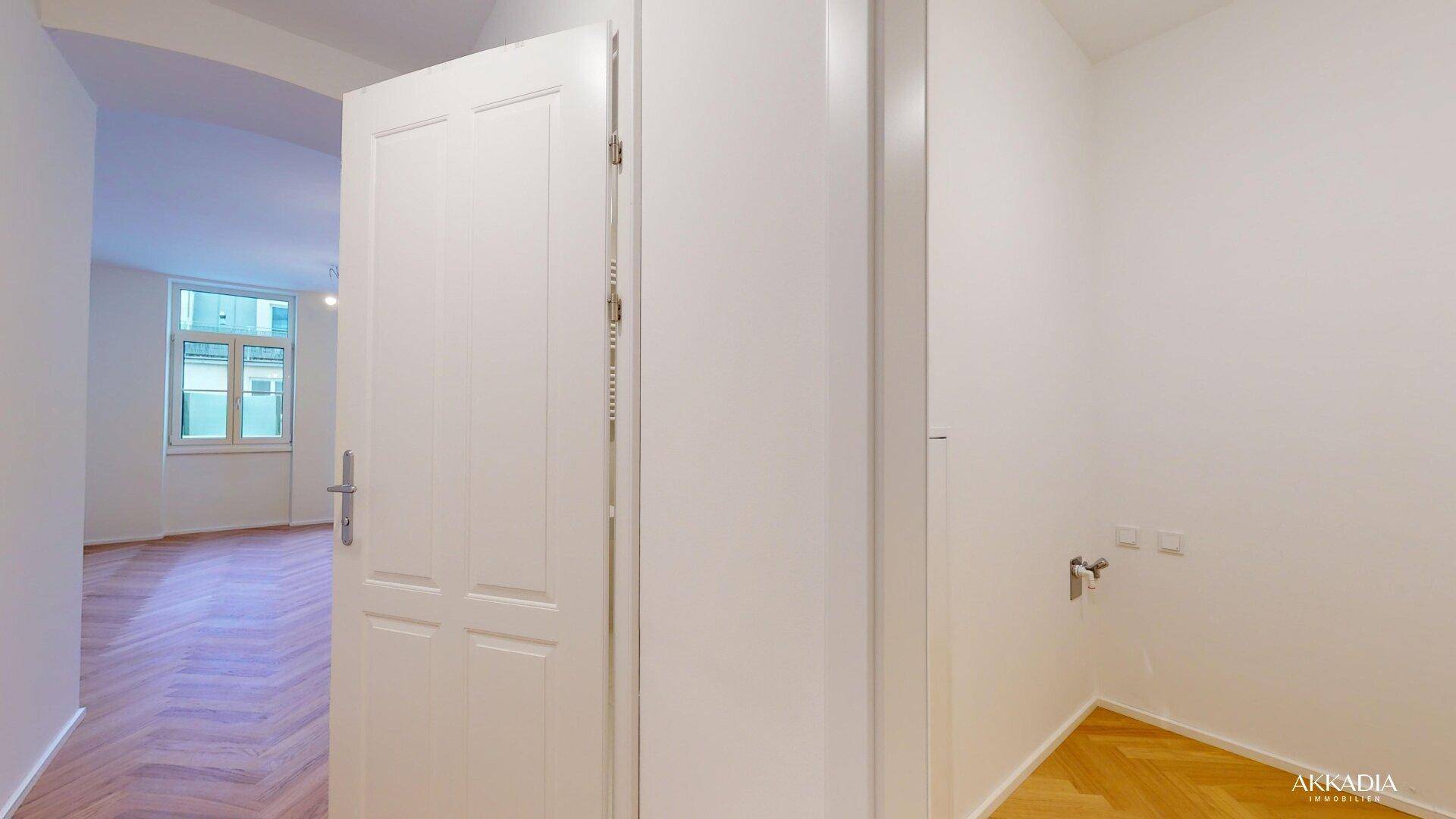 Flur mit Fischgrätparkett und Blick in einen angrenzenden Raum, vorbereitet für Installationen.