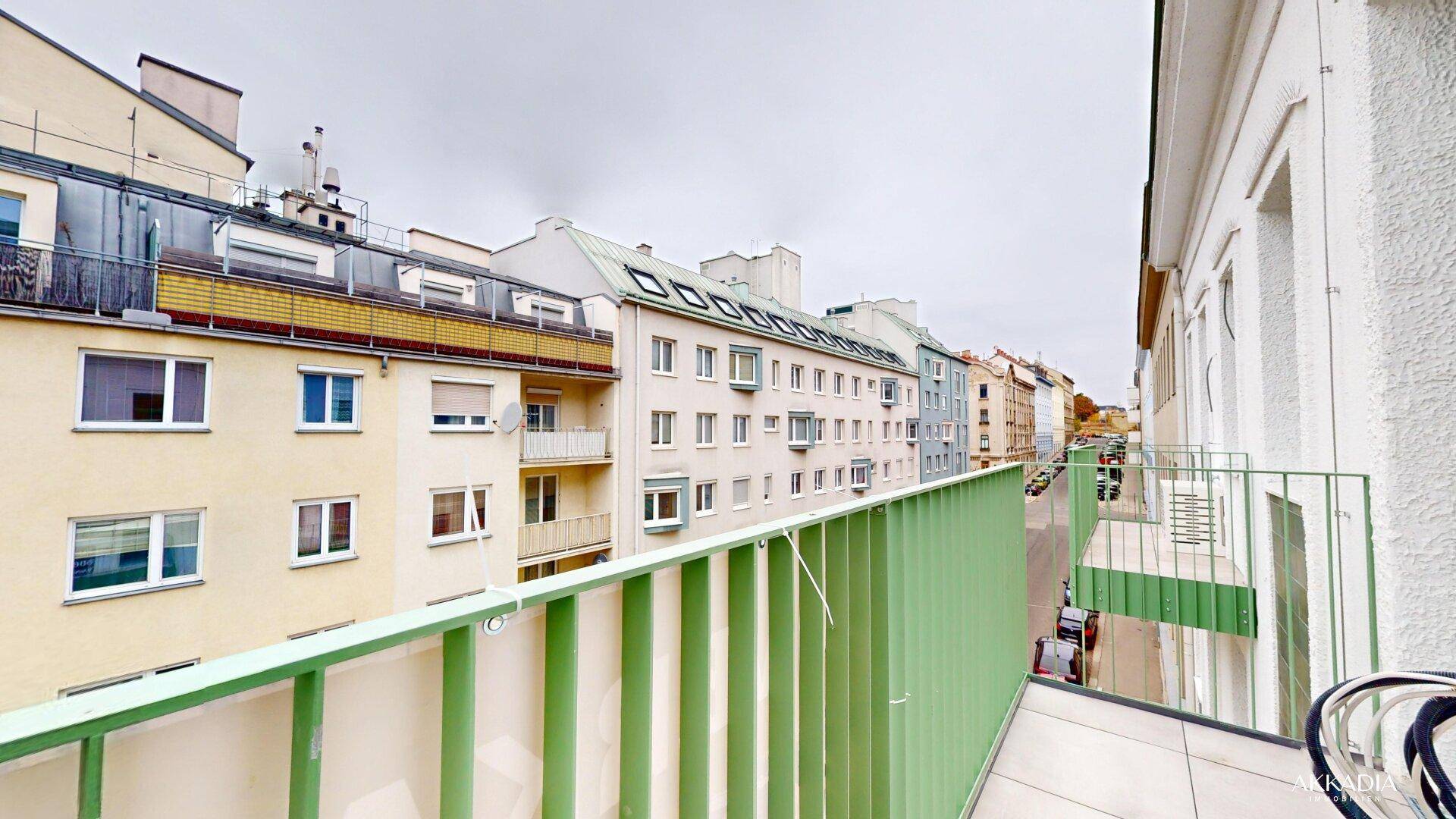 Weitblick vom Balkon über die Dächer der Stadt und die belebte Straße.