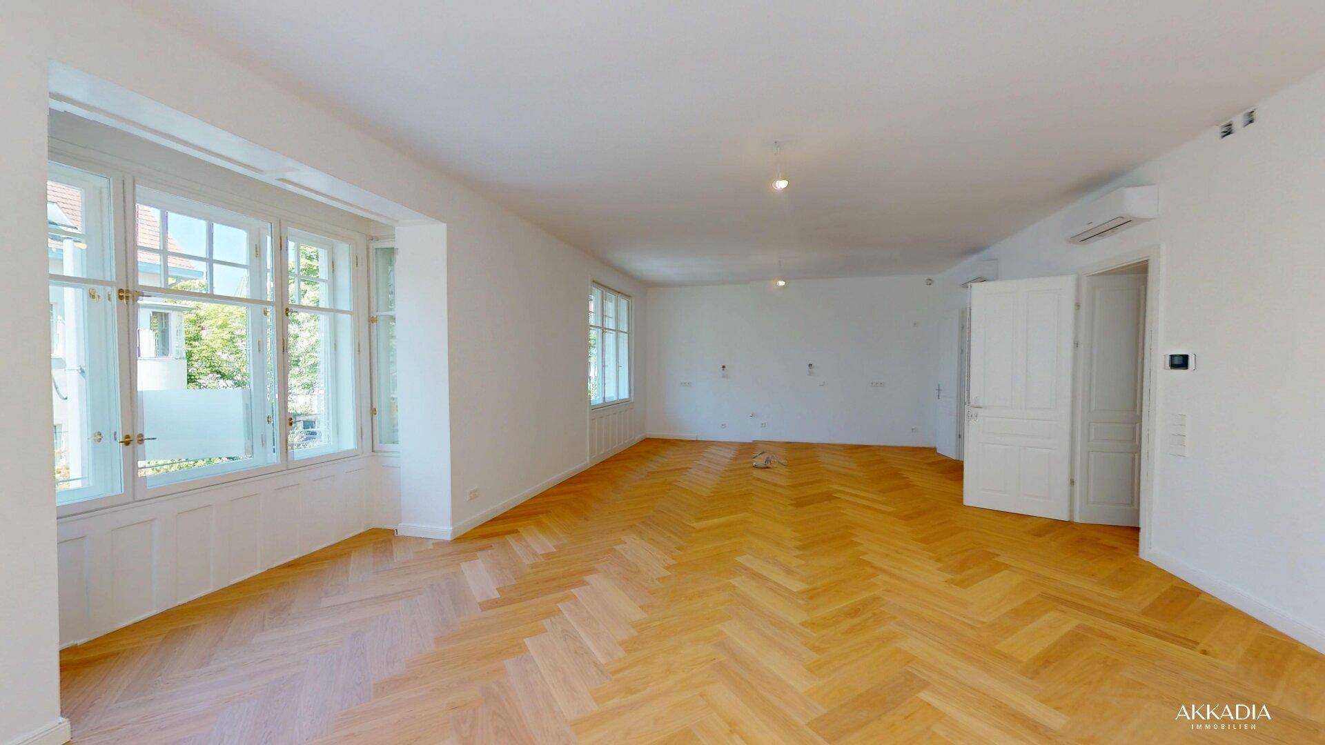 Geräumiges, helles Zimmer mit Fischgrätparkett, hohen Fenstern und Klimaanlage.