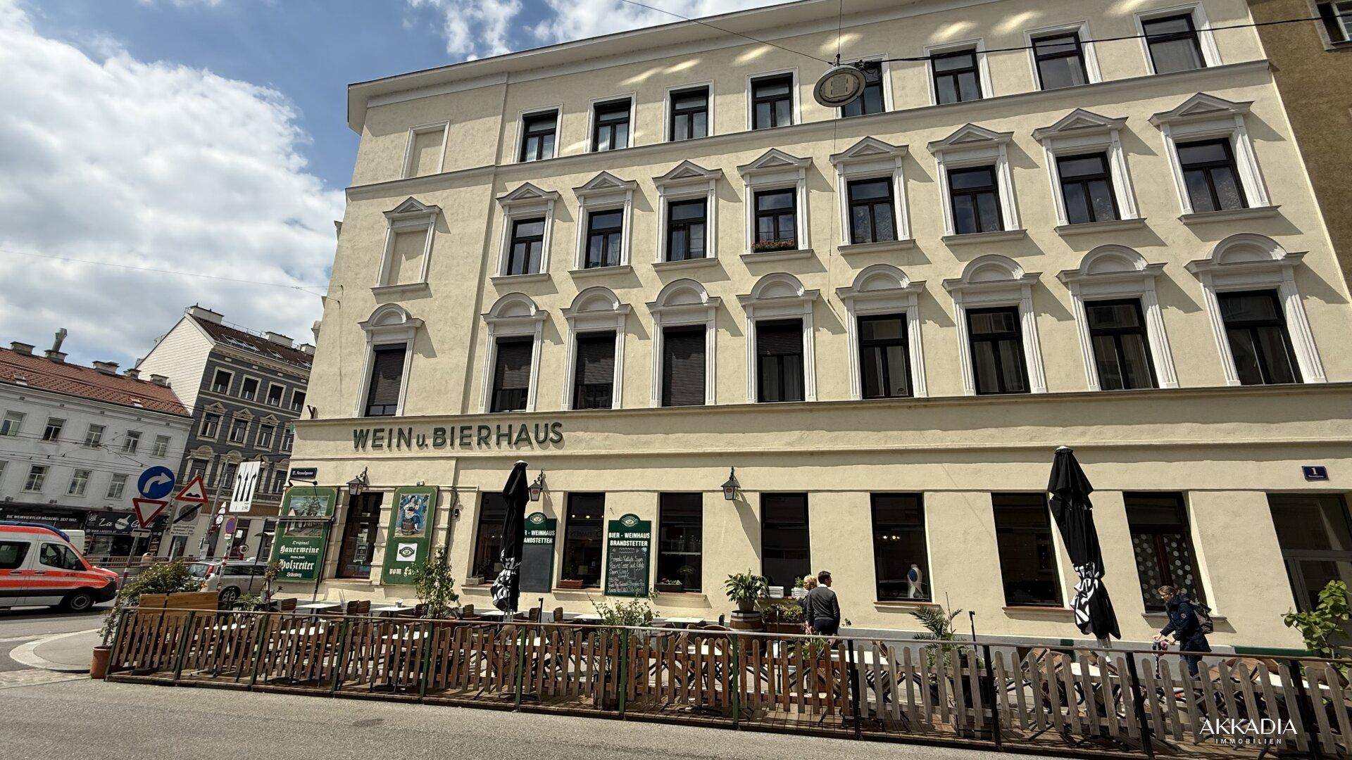 Die Fassade eines mehrstöckigen Gebäudes, das ein Wein- und Bierhaus beherbergt, an einem sonnigen Tag.