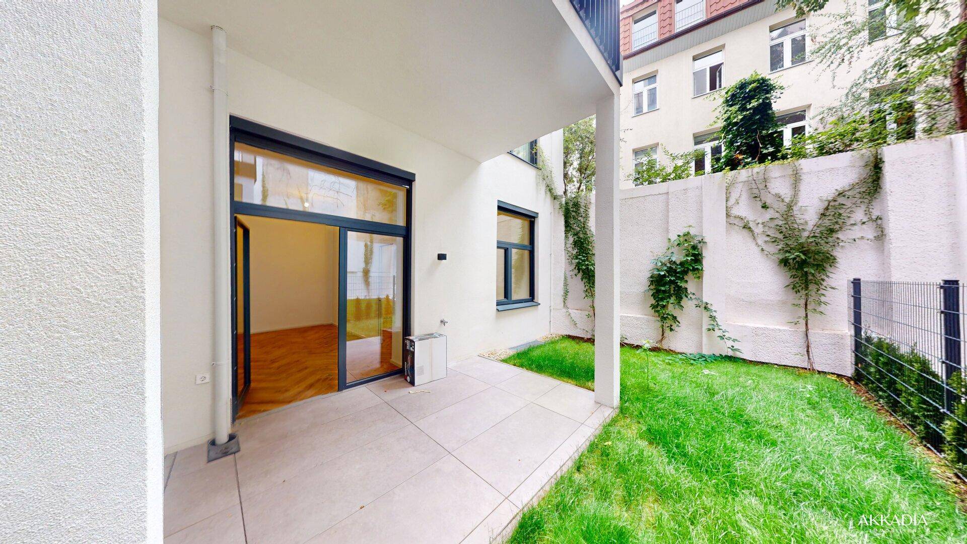 Ruhiger Gartenbereich mit gepflasterter Terrasse und viel Grün für Entspannung im Freien.