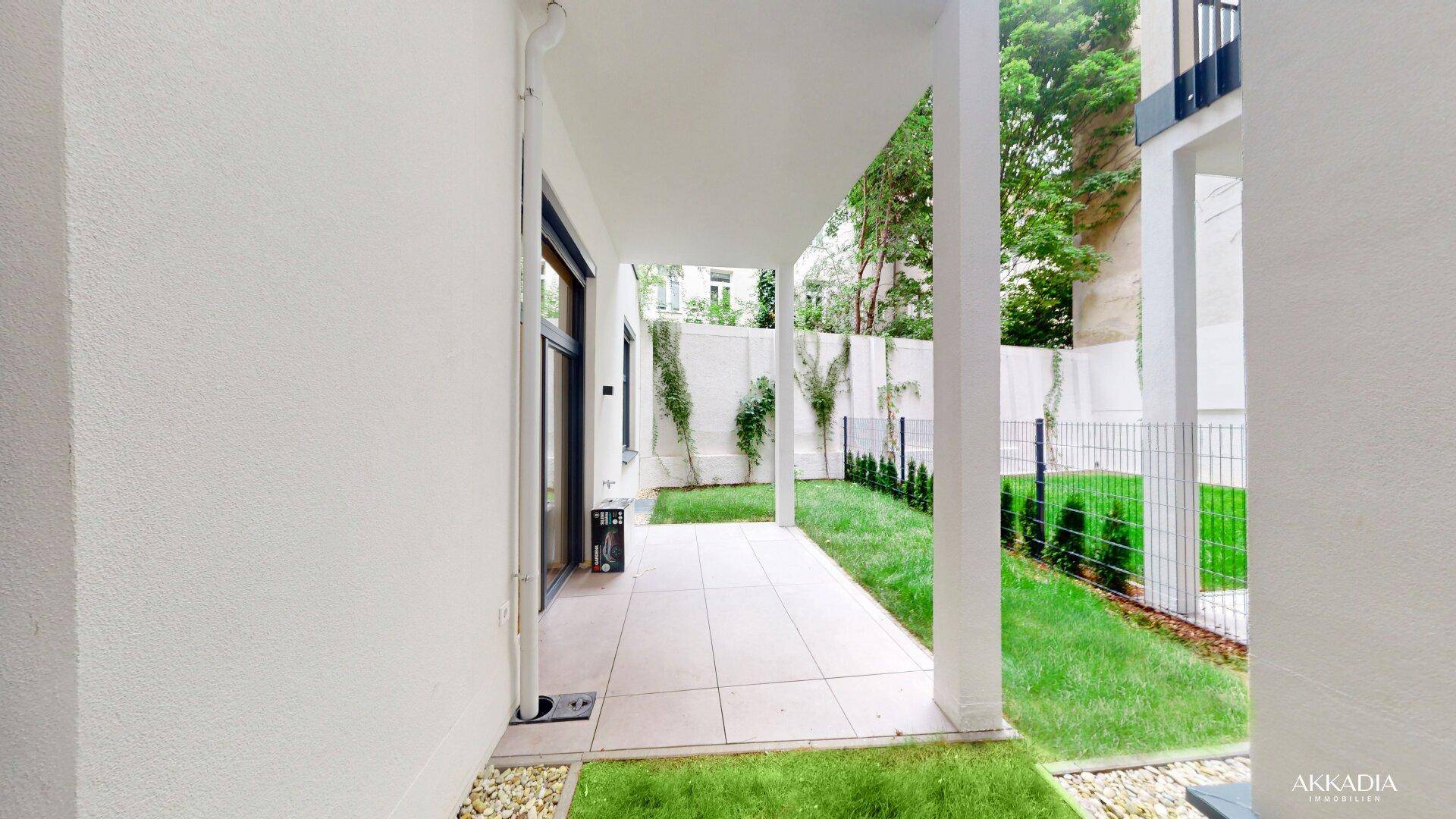 Überdachte Terrasse mit angrenzendem Rasenbereich, ideal für gemütliche Stunden im Freien.