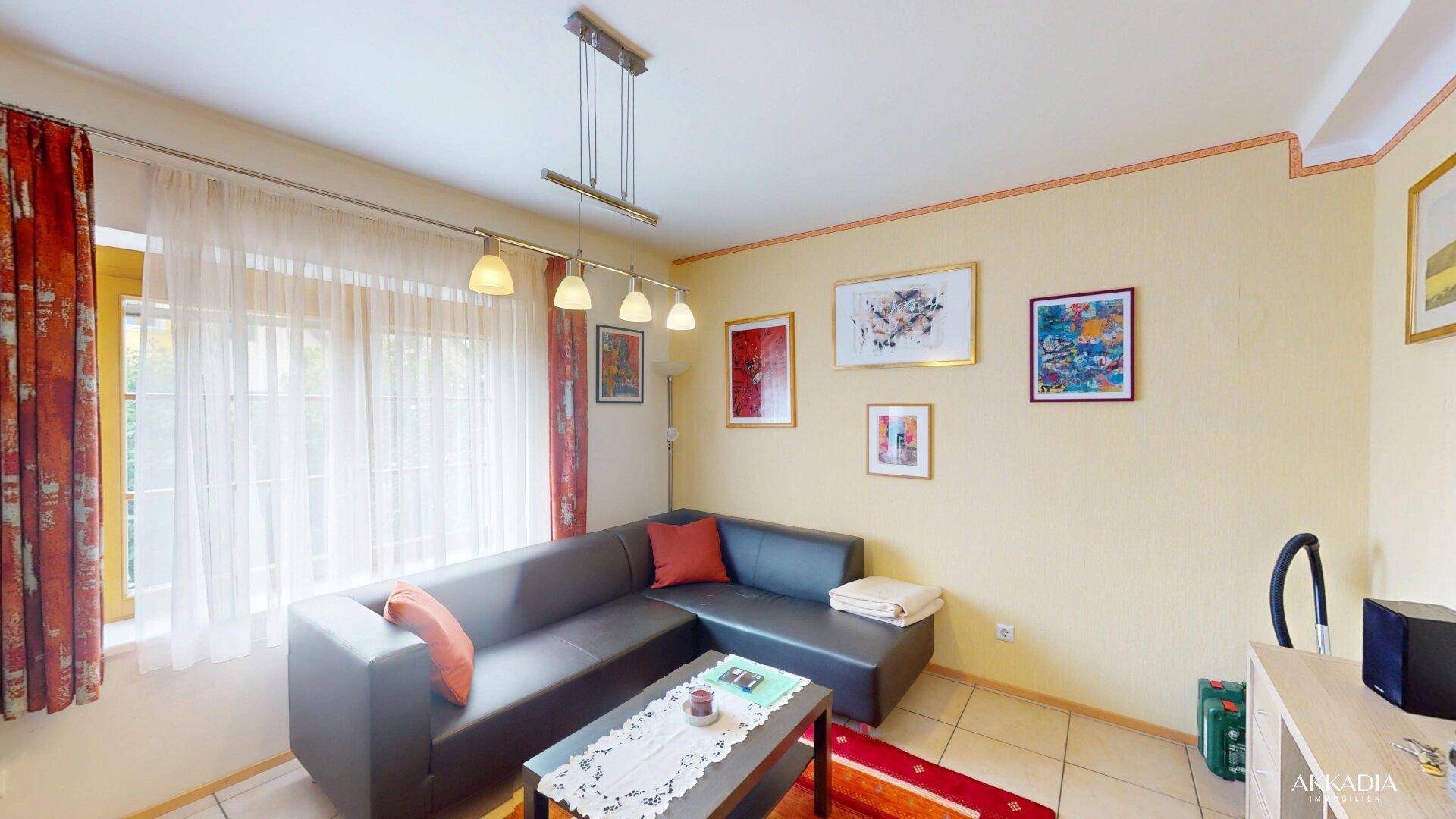 Gemütliches Wohnzimmer mit Ecksofa, Couchtisch und farbenfrohem Teppich.