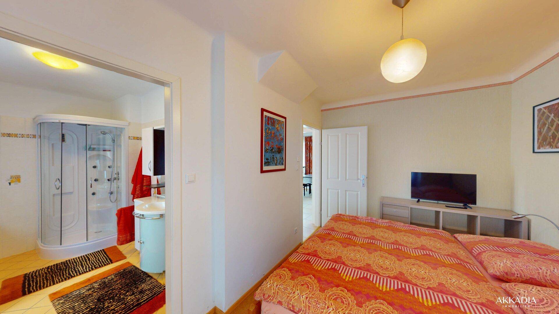 Schlafzimmer mit Doppelbett und direktem Zugang zum Badezimmer.