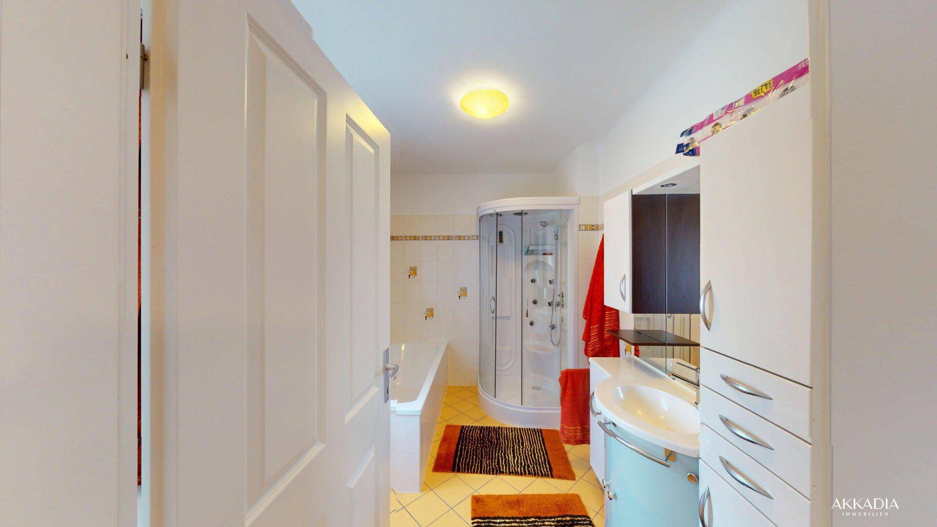 Geräumiges Badezimmer mit Badewanne, Duschkabine und Waschbecken.