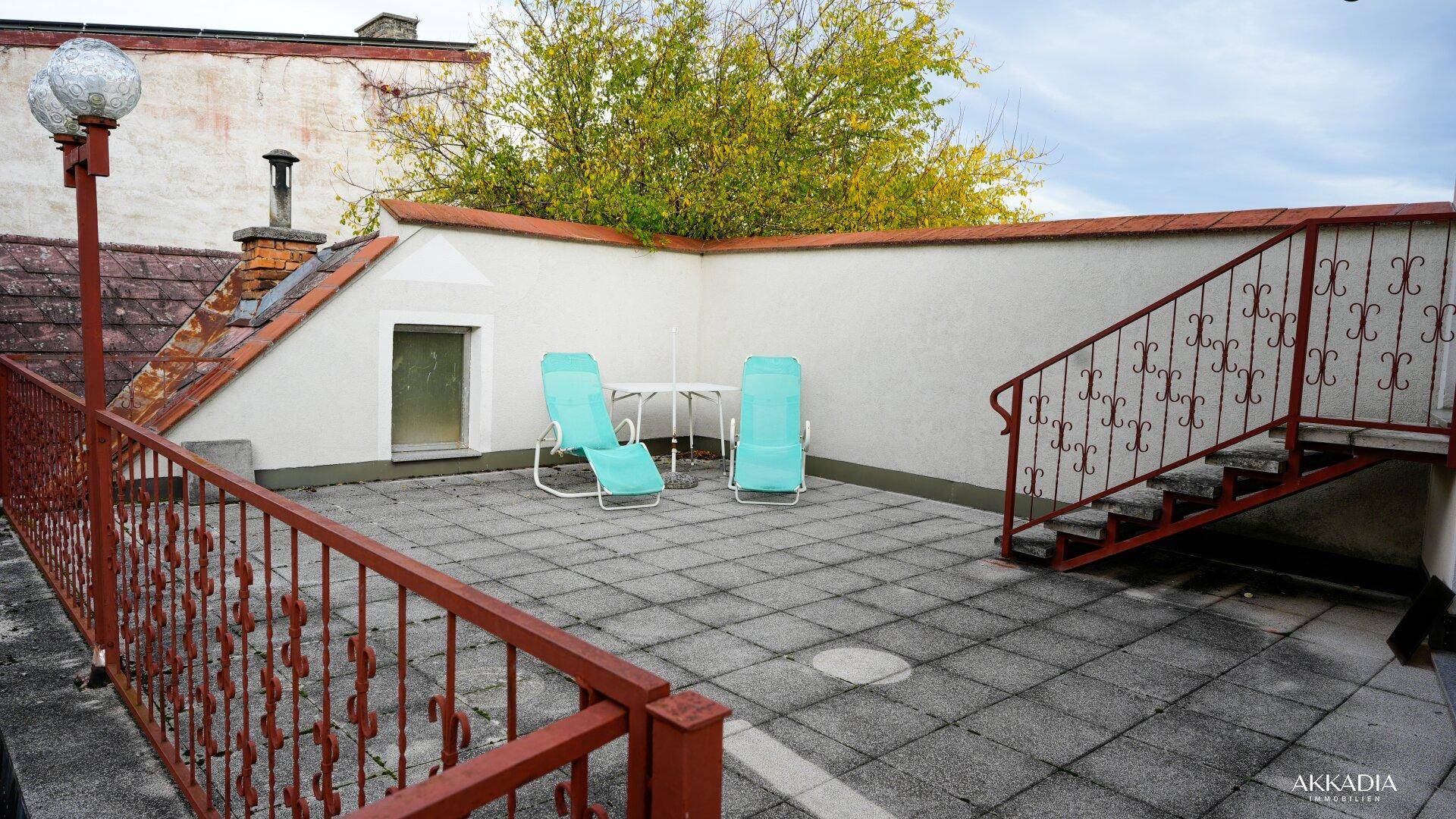 Geräumige Dachterrasse mit Liegestühlen und Blick auf die Umgebung.