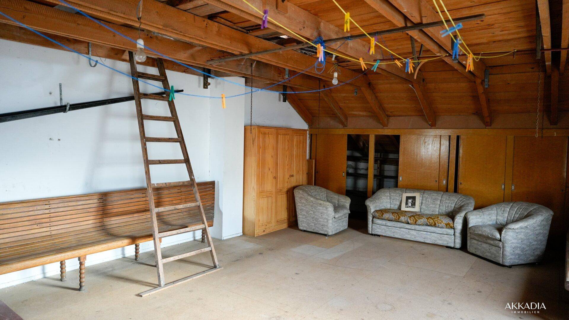 Dachboden mit Holzbalken, Sitzbänken und viel Platz für Lagerung oder Ausbau.