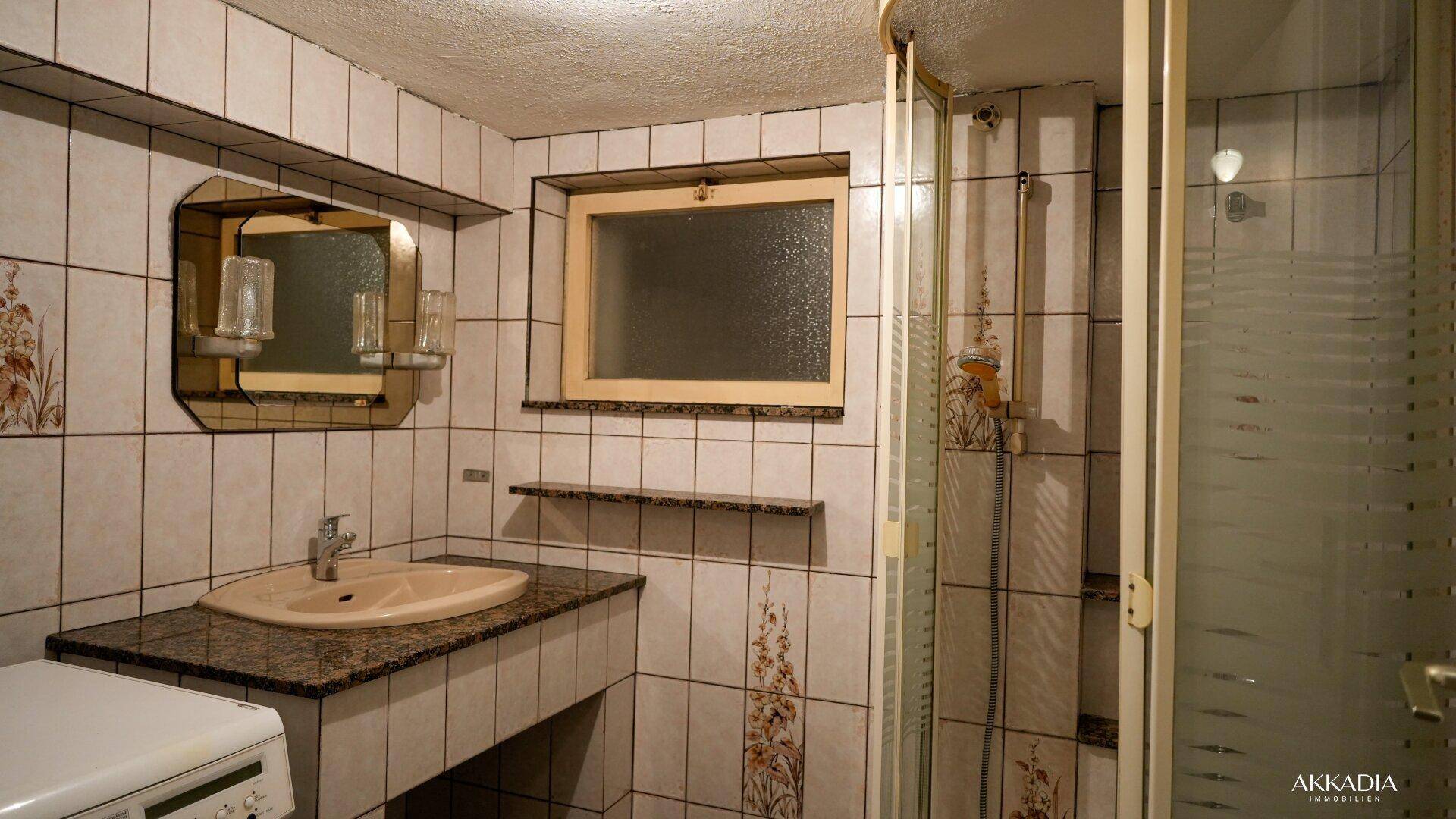 Badezimmer mit Dusche, Waschbecken und Fliesen im Vintage-Stil.