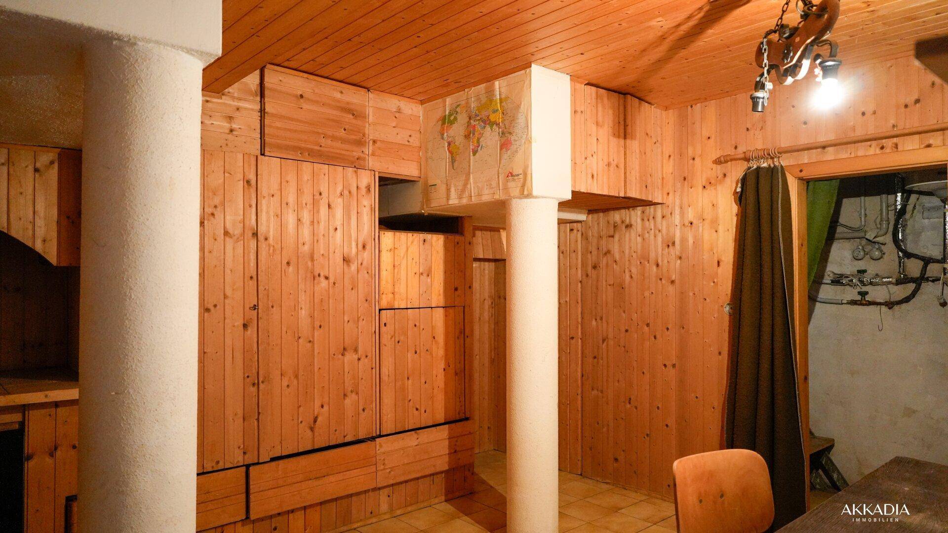 Kellerraum mit Holzvertäfelung und Säulen, ideal als Hobbyraum oder Lager.