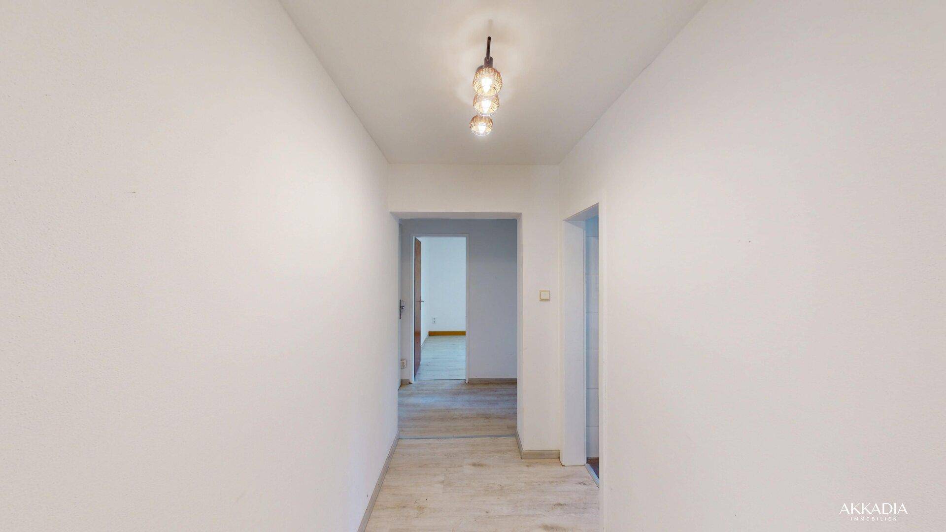 Heller Flur mit Laminatboden und Zugang zu verschiedenen Zimmern im Haus.