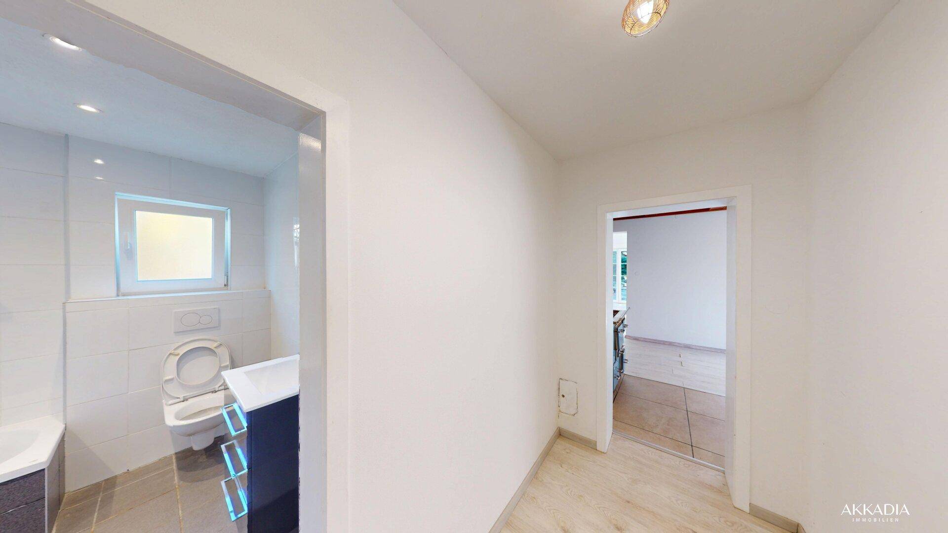 Flur mit Blick auf das moderne Badezimmer und weitere Räume.