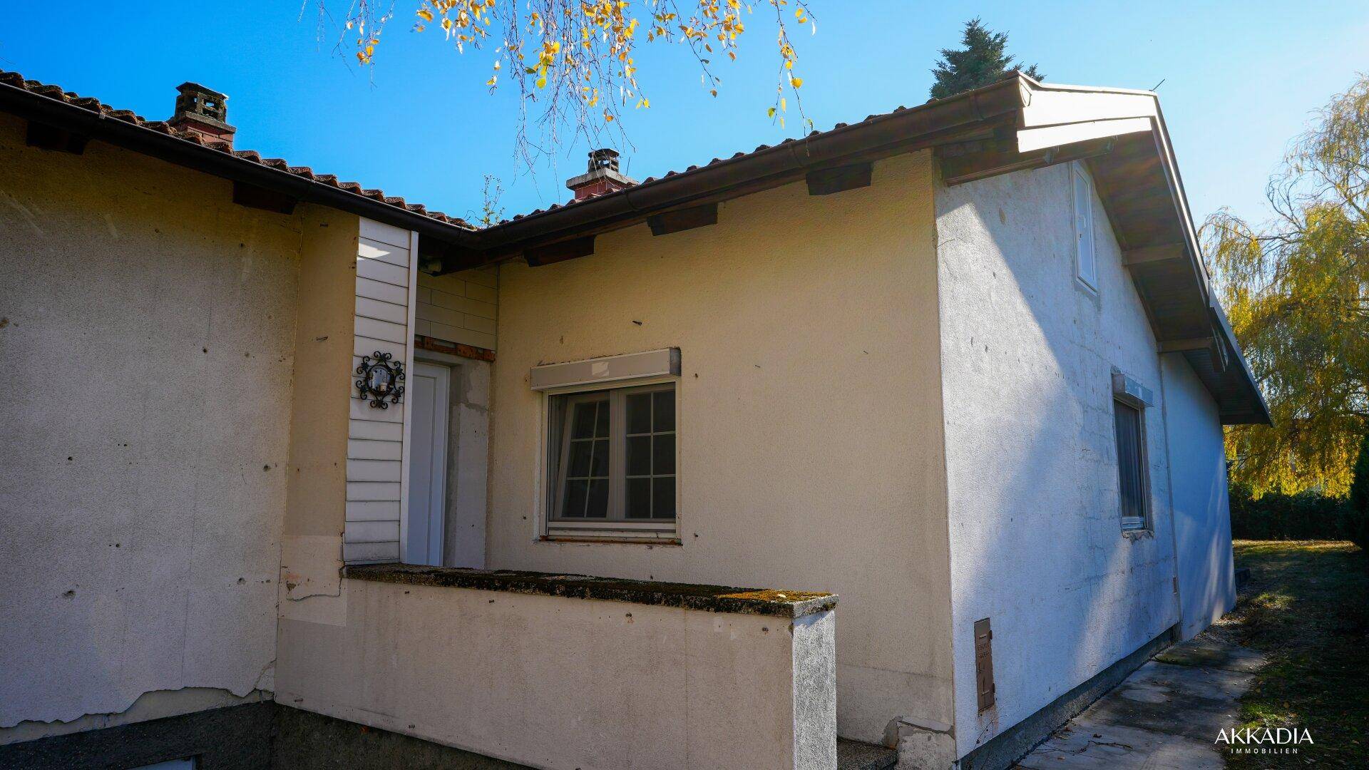 Seitenansicht des Hauses mit kleiner Terrasse und Blick auf den Garten.