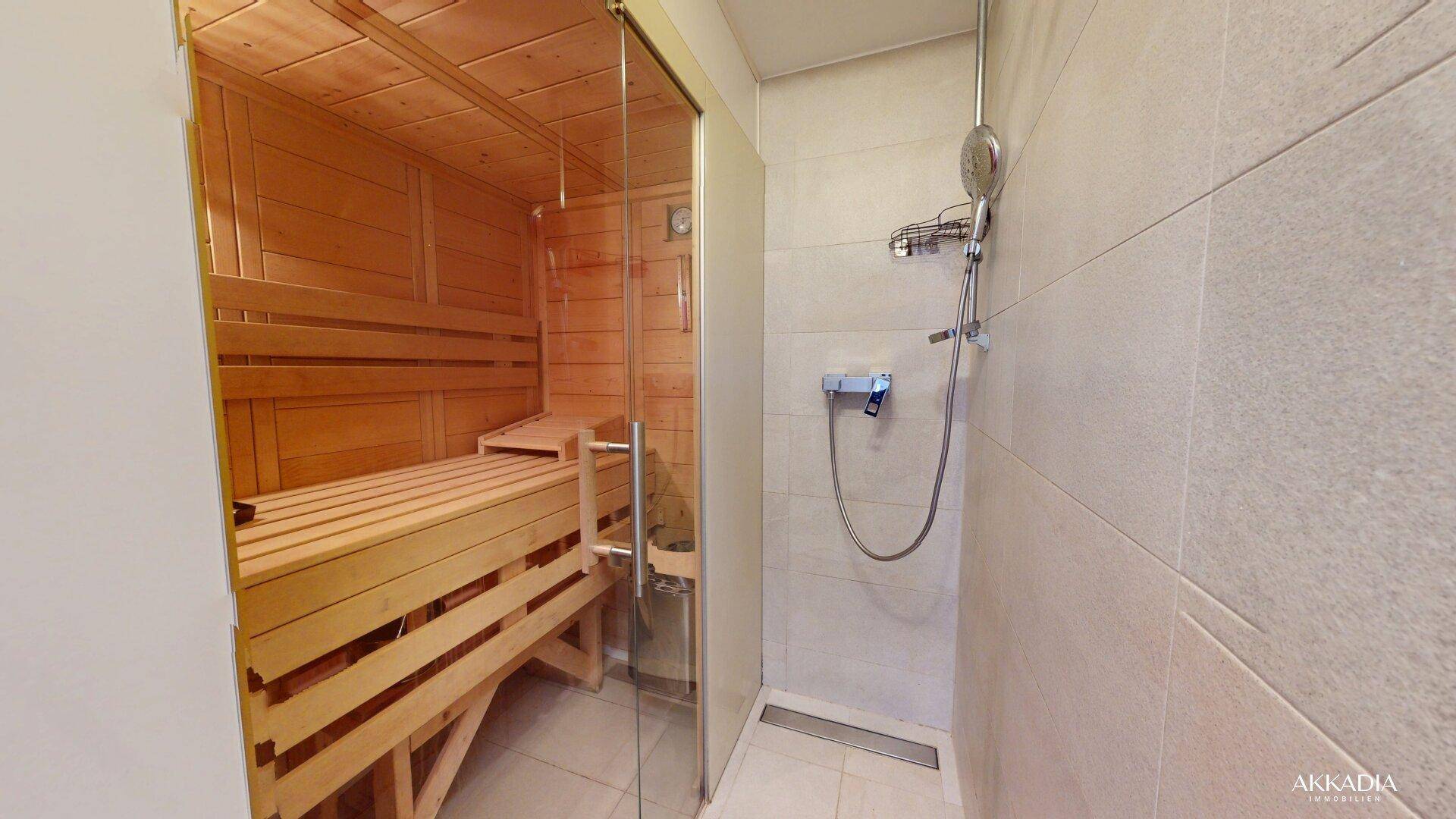Modernes Badezimmer mit begehbarer Dusche und einer integrierten Holzsauna für Wellness.