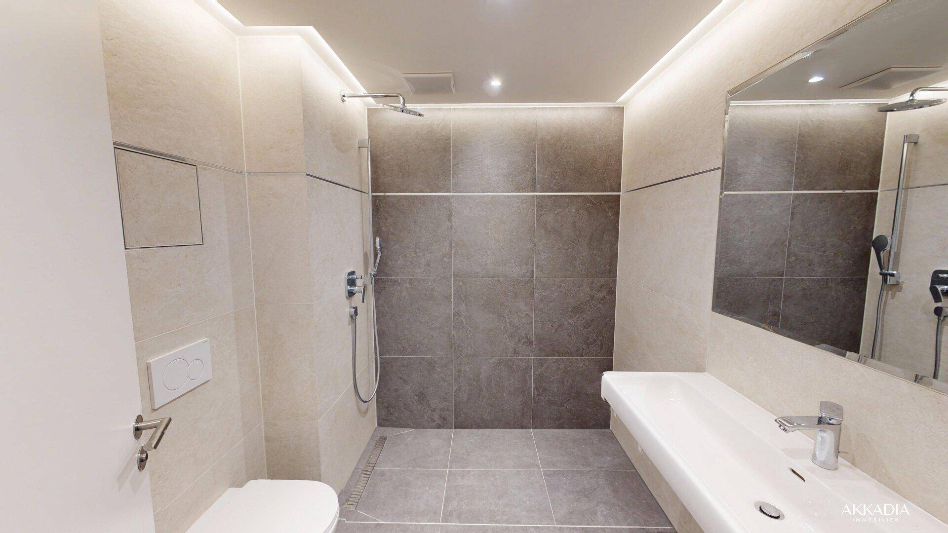 Modernes Badezimmer mit ebenerdiger Dusche, wandhängendem WC und stilvollen Fliesen.