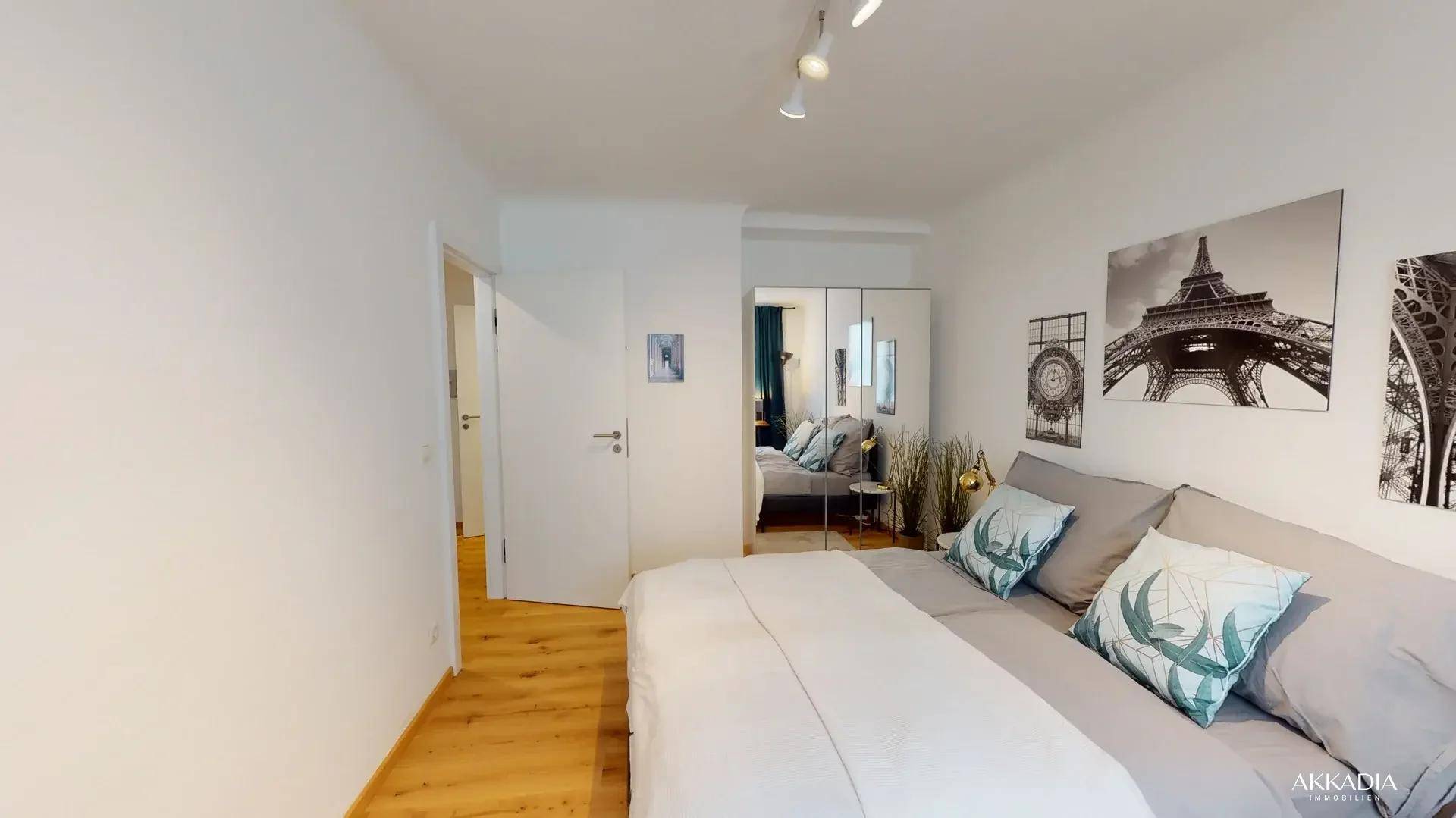 Schlafzimmer mit Doppelbett, Holzboden und großem Spiegelschrank.